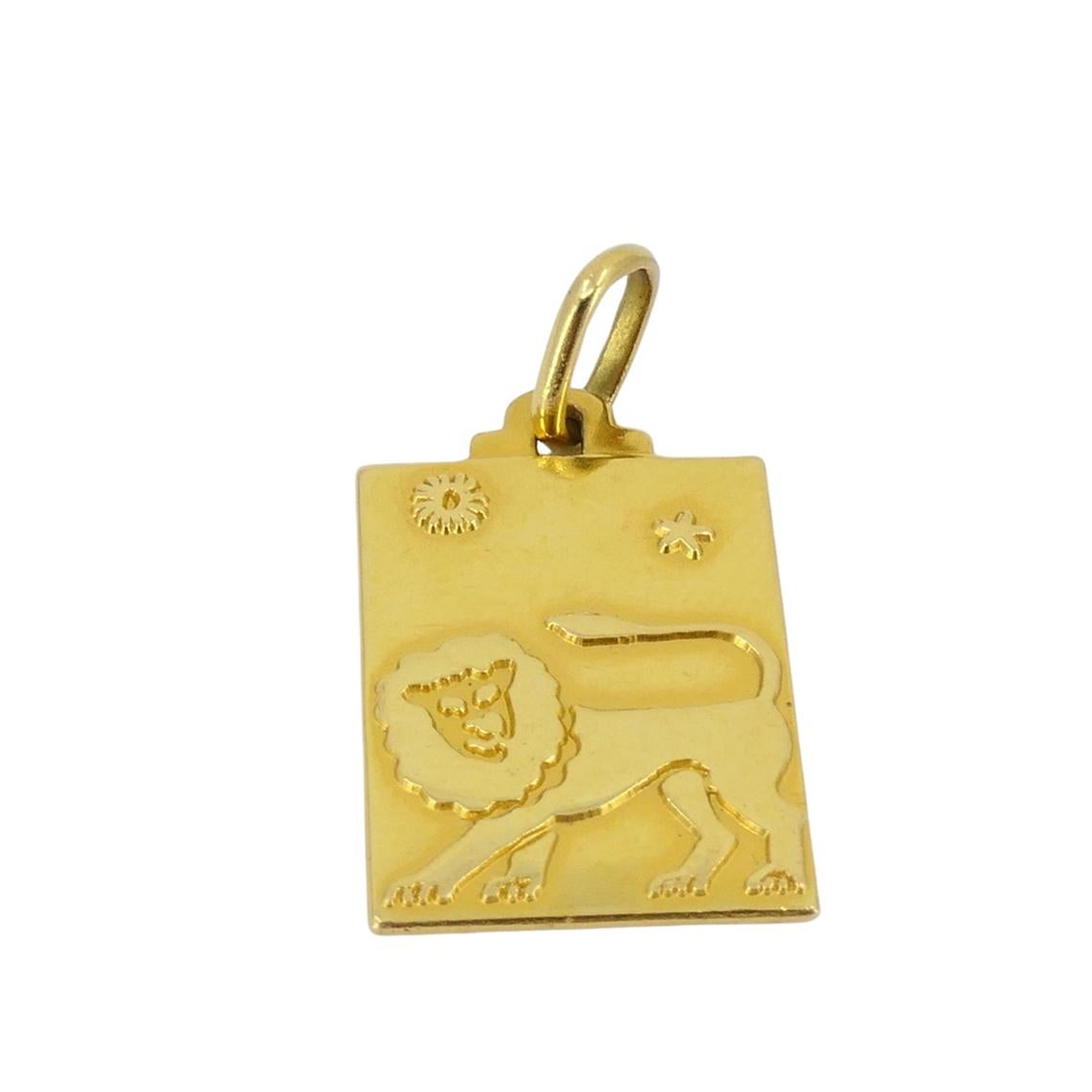 This vintage charm is crafted in 18k gold and features a rectangular design engraved with the Leo zodiac sign. The front of the charm shows a lion in profile, with detailing on the mane, face, and body. Above the lion are small celestial symbols,