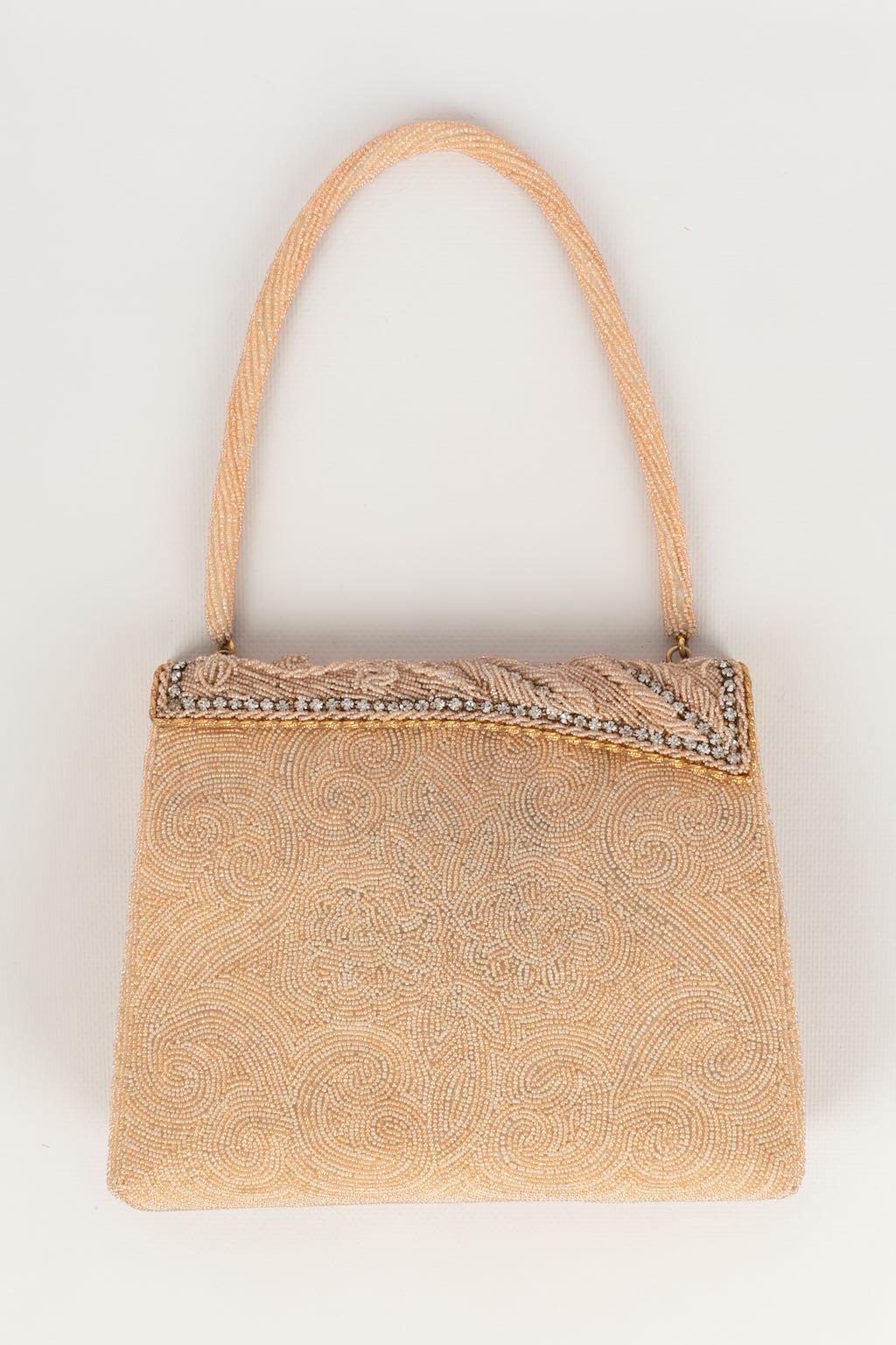 ANONYMOUS -Small pink bag embroidered with Leo Miller beads.

Condition:
Good condition

Dimensions :
Width: about 20 cm - Height: 17 cm - Handle: 35 cm - Depth: 5 cm

SKU:S934