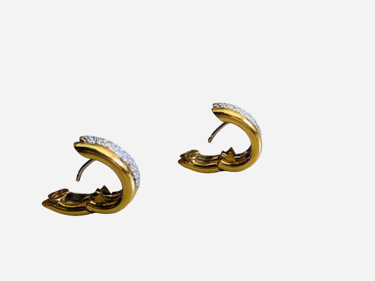 This is a Leo Pizzo 18K/750 white and yellow gold diamonds pair of earrings. It depicts a double oval hoops earrings, one, white gold and the other one, yellow gold attached to each other. The white gold hoop is embellished by pave diamonds. Each
