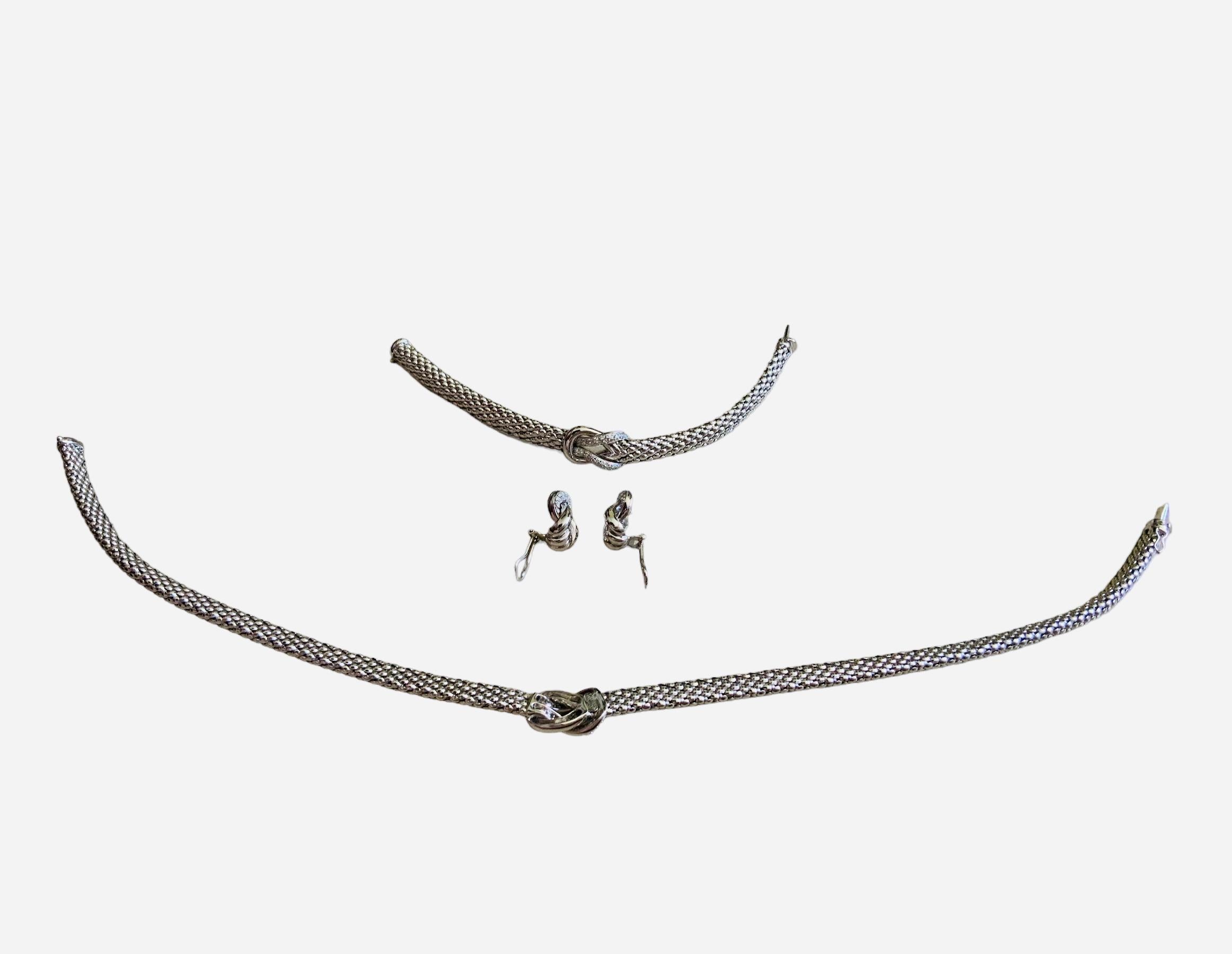 This is a Leo Pizzo set of 18K ( 750) white gold and diamonds bracelet, a pair of earrings and a necklace. Both the bracelet ( L= 7.75 in ) and necklace ( L= 16.5in  ) depict a snake like belts joined in the center by an Hercules, double or love