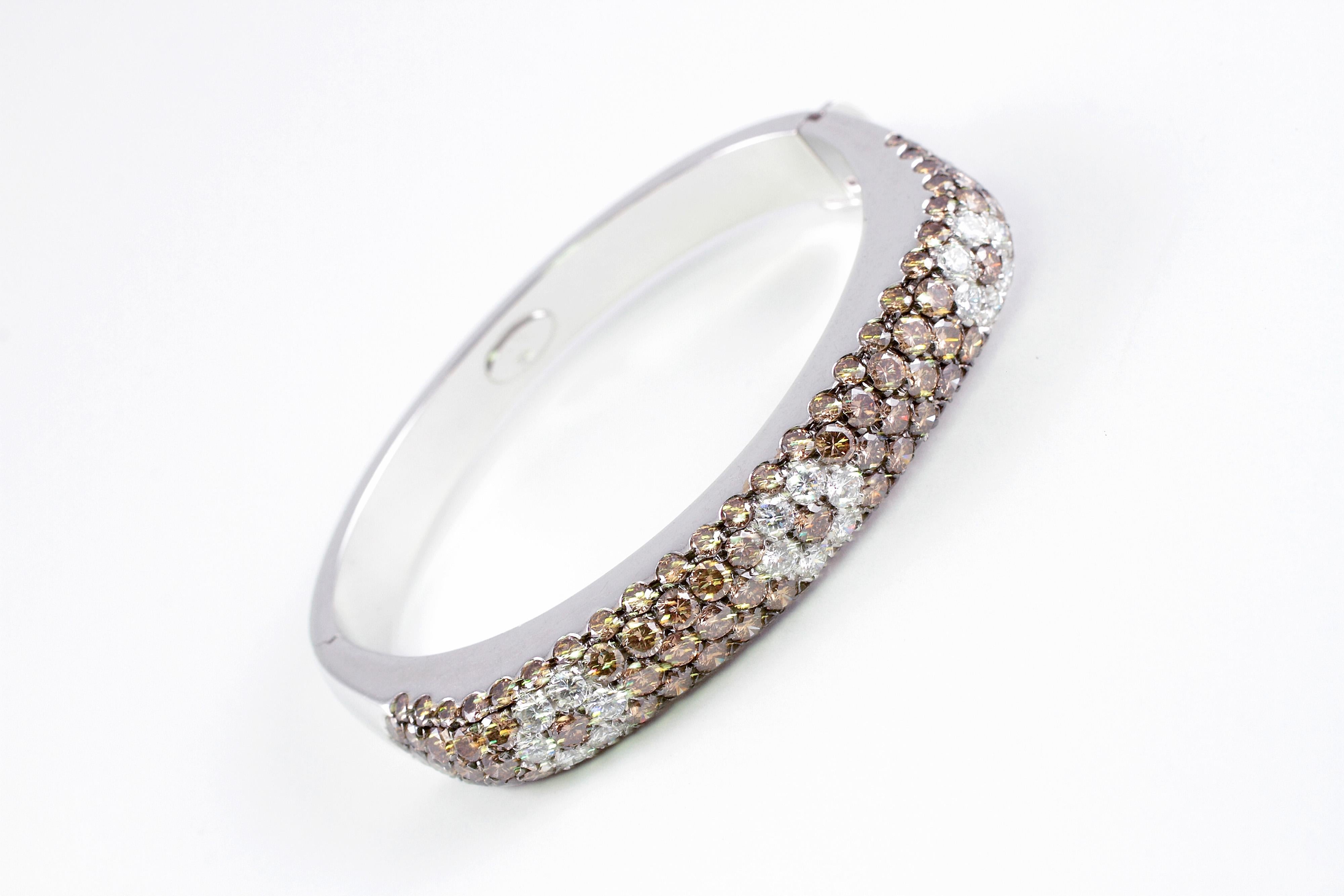 This 18 karat white gold, hinged bracelet is by Leo Pizza and features three delightful white diamond flower shapes, surrounded by bead-set, brown diamonds.   Such a stunning contrast!  The stated total weight of all diamonds is 9.90 carats and the