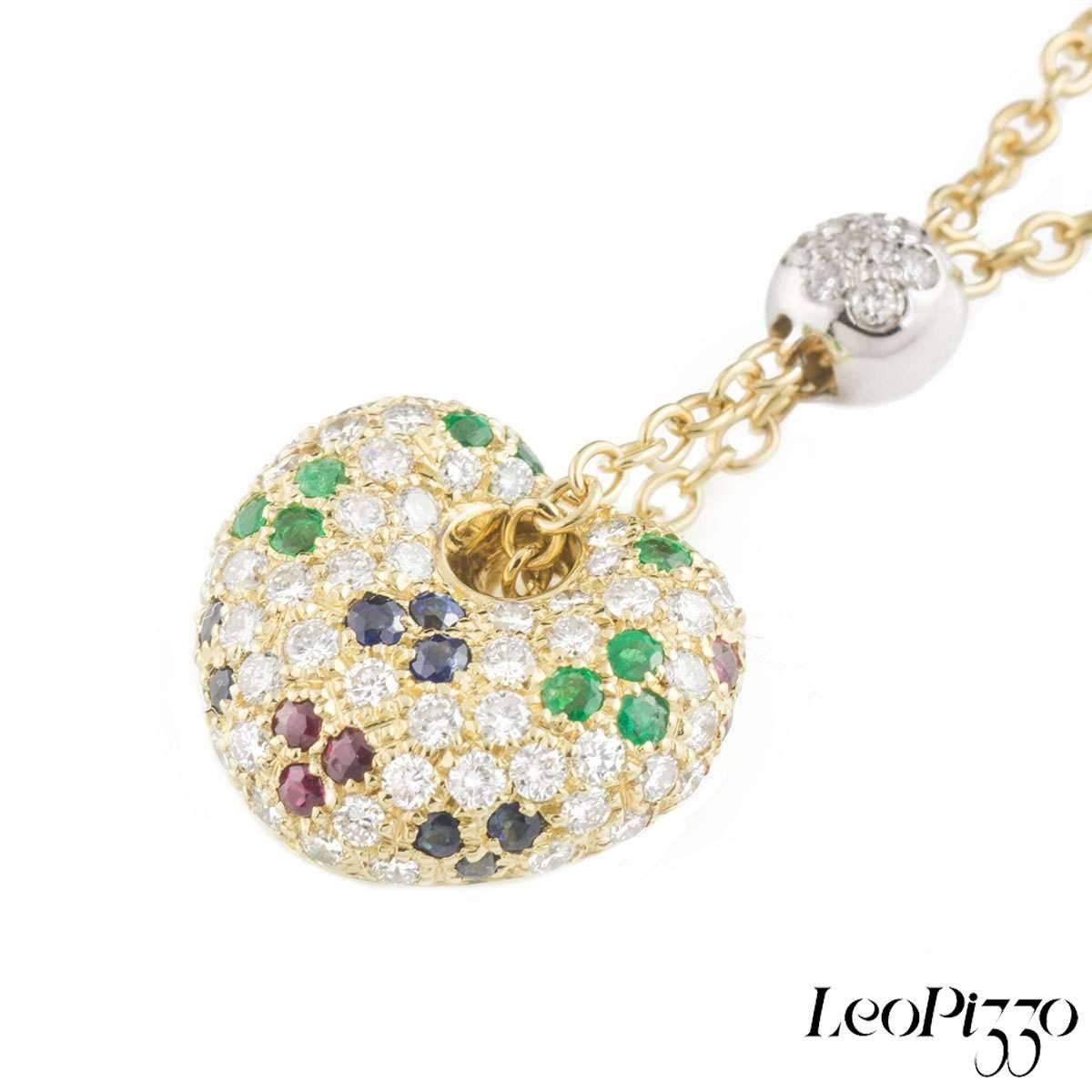 A beautiful 18k yellow gold multi-gemstone Leo Pizzo heart pendant. The pendant comprises of a heart motif encrusted with round brilliant cut diamonds, sapphires, rubies and emeralds. Complementing the heart is a ball motif leading up a chain with 7