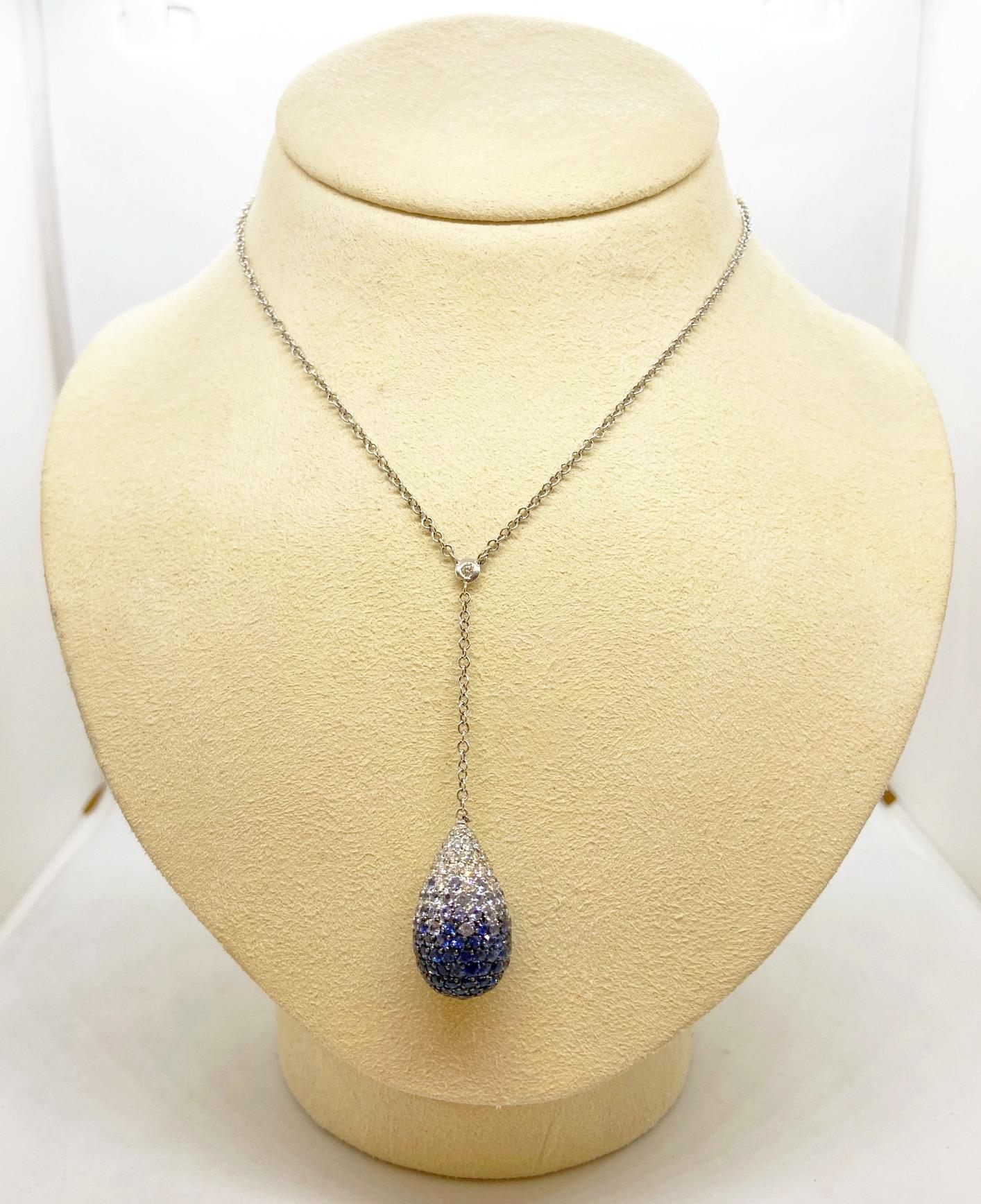 18-karat white gold necklace, with a dew drop pendant graduating in color from white diamond to light shades to darker blue sapphire pavé, on white gold chain with a bezel-set round brilliant white diamond connector.

Blue sapphire weight: