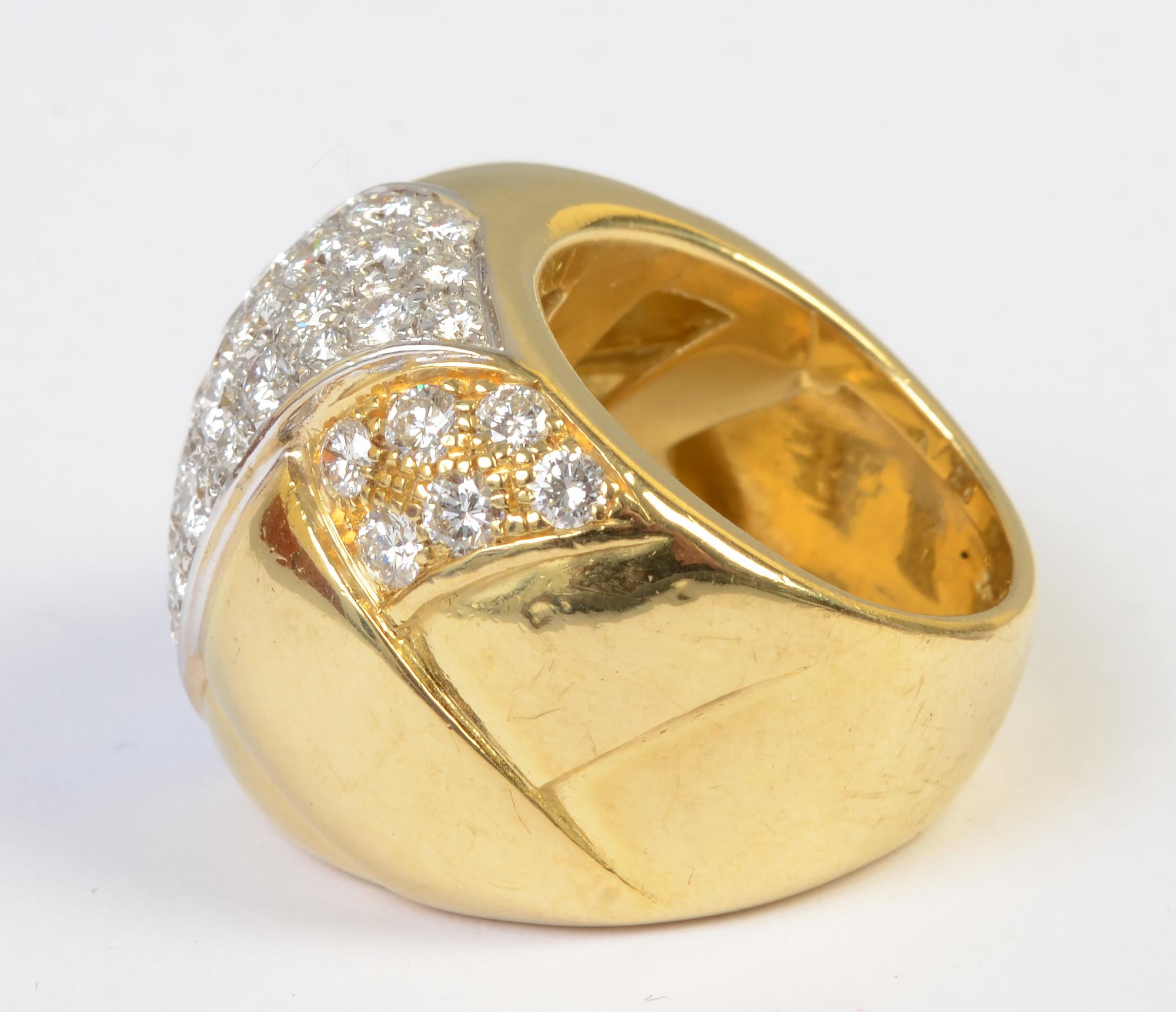 Absolutely eye dazzling wide band gold ring with 4.25 carats of VS diamonds; F color. The ring is domed and has a slightly braided design in the gold. The diamonds are set on a diagonal with smaller clusters of inset stones on either side. The front