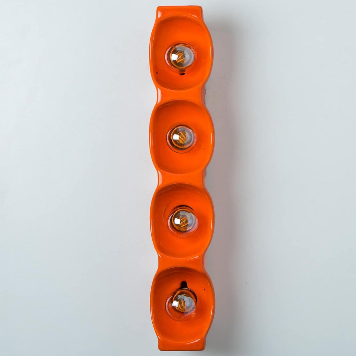 Applique en céramique orange, fabriquée par Leola dans les années 1960. Cette lampe est un mélange de design ludique et épuré, ce qui en fait une pièce d'affirmation audacieuse qui ajoute du caractère à n'importe quel espace.

Nettoyé et bien câblé,