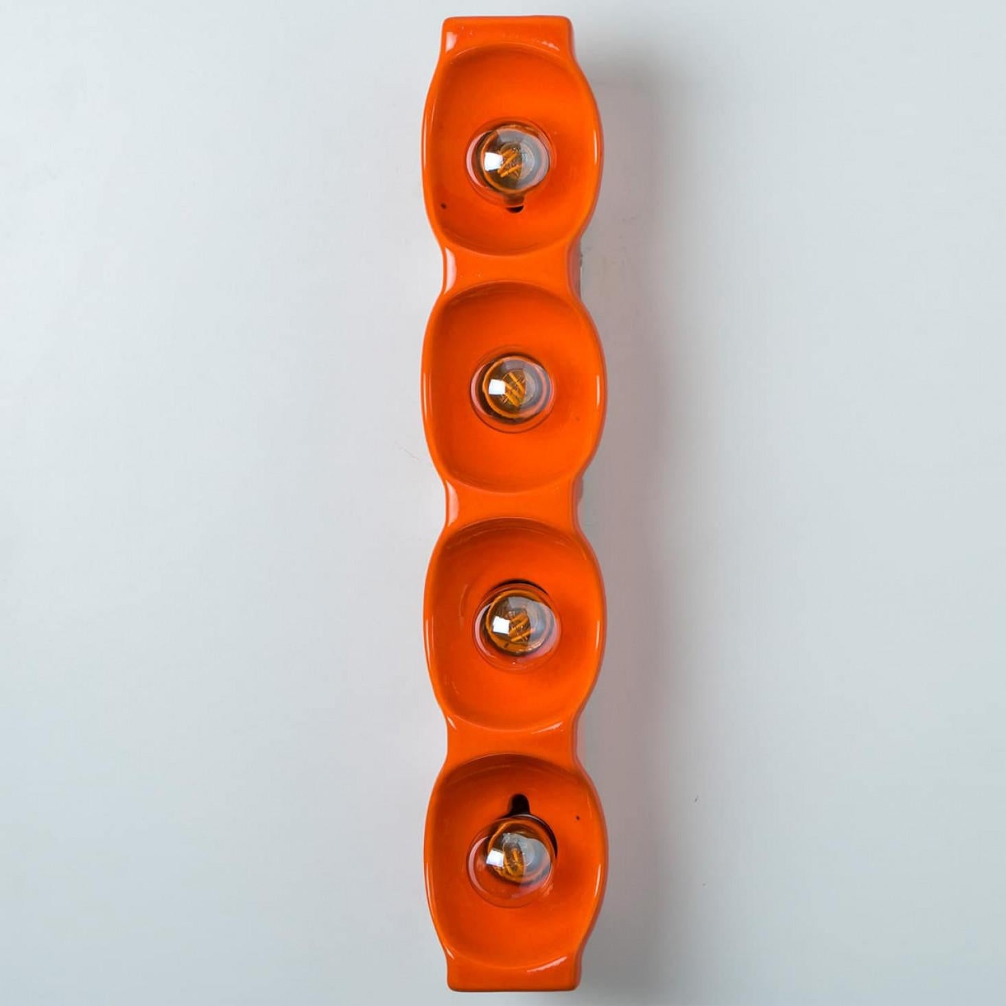 Orange ceramic wall light, manufactured by Leola in the 1960s. This lamp is a blend of playful and sleek design, making it a bold statement piece that adds character to any space.

Cleaned and well-wired, in full working order and ready to use.

