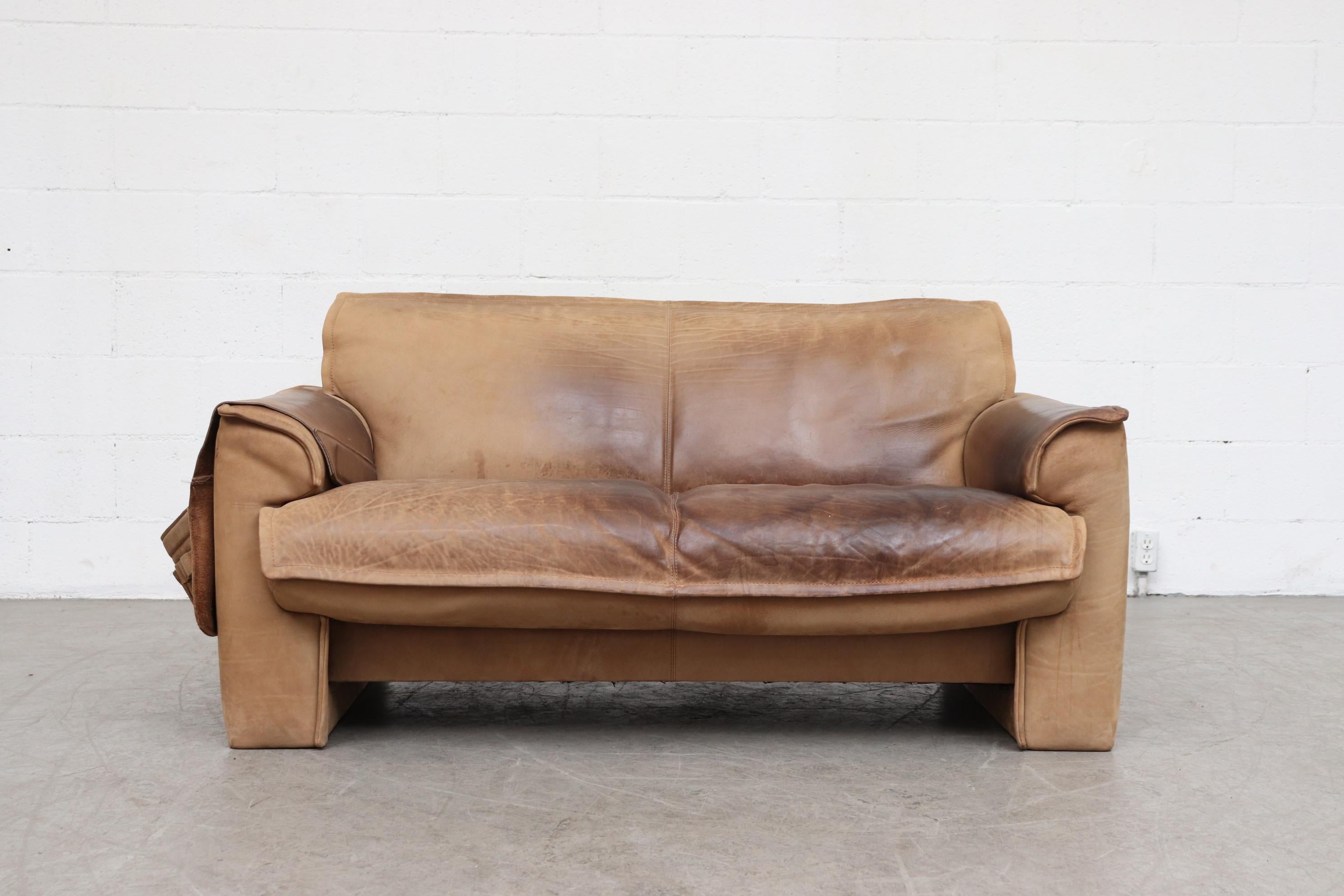 Leolux Buffalo leather loveseat sofa in very original condition with heavy patina and visible signs of wear. Comes with super cool weighted and removable side saddle pouch for storage (books, magazines, remotes, etc.). Center seam is split a little