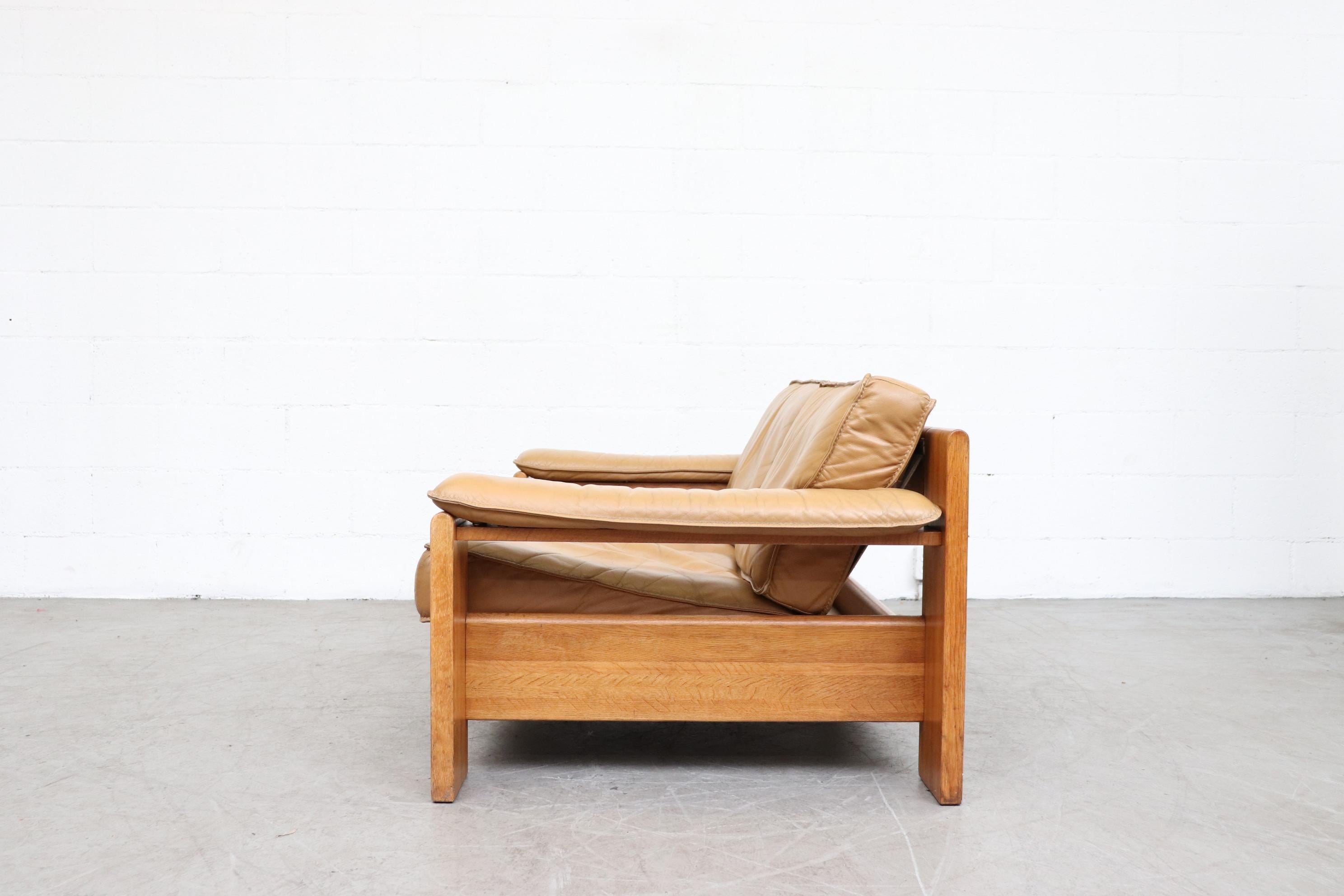 Leolux wood framed natural leather loveseat. Beautifully worn natural leather cushions. In original condition with visible signs of wear consistent with age and use. Color may vary from the photo.