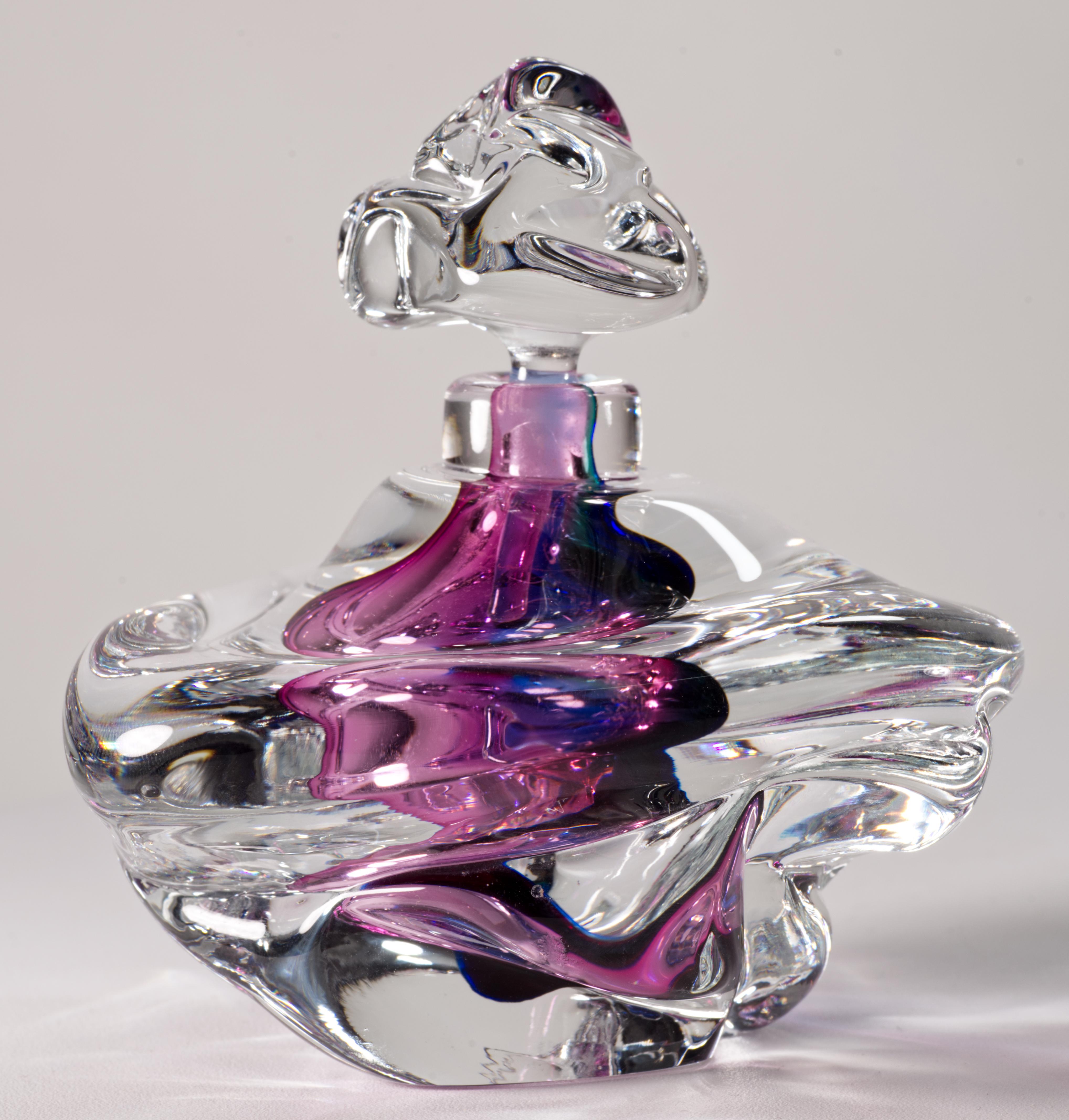  Sculptural vintage studio glass perfume bottle features a vibrant, jewel-toned amethyst colored glass inner chamber, encased in thick layer of clear glass in sommerso technique. The clear glass stopper has a long dipper stem with an abstract