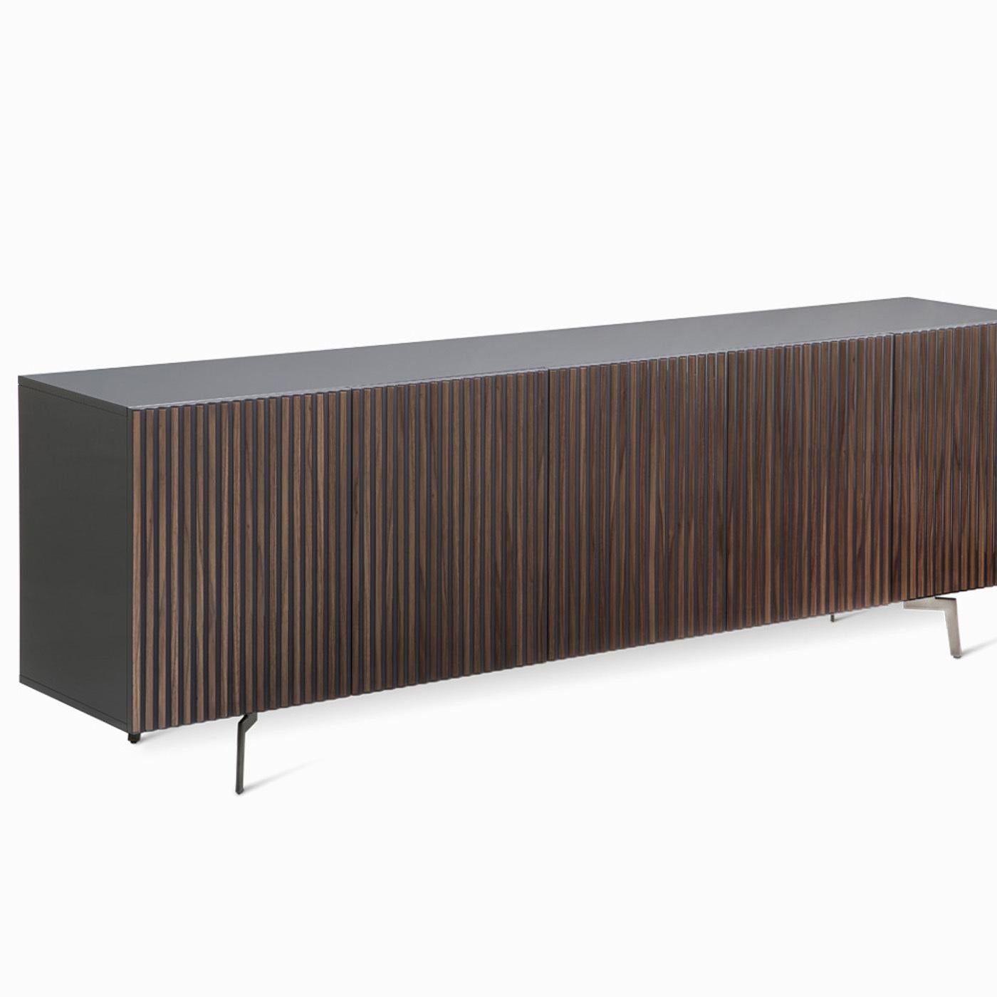 A capacious and elegant sideboard, this piece features five doors and spectacular allure. An exercise in contrasts, the black-lacquered wooden frame is sleek and essential, enriched with Canaletto walnut wood vertical inserts on the front panels.