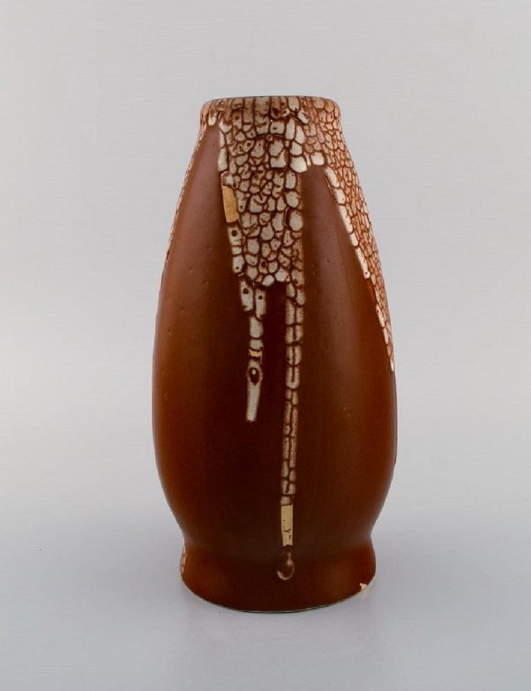 Léon Pointu (1879-1942), France. Grand vase Art déco en grès émaillé. 
Belle glaçure courante de couleur crème sur un fond brun rougeâtre. 
1930s.
Mesures : 25.5 x 13 cm.
En parfait état.
Signé.