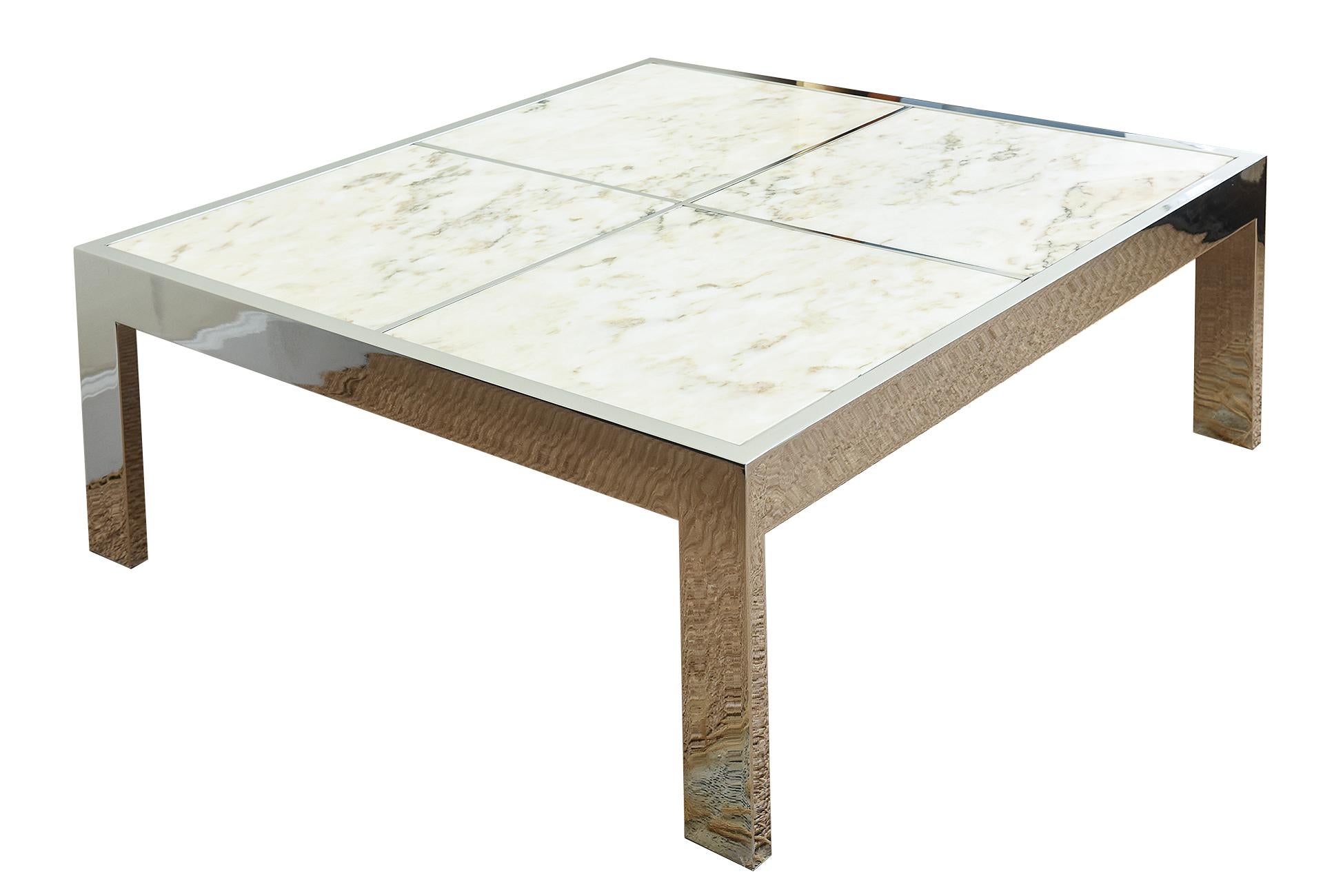 This chic modern and timeless Pace Cocktail table was designed by Leon Rosen. It is vintage from the 70's and has a Parsons style chromed steel flat tubular column legs with 4 inserts of marble with variegated forms. The marble is separated by the