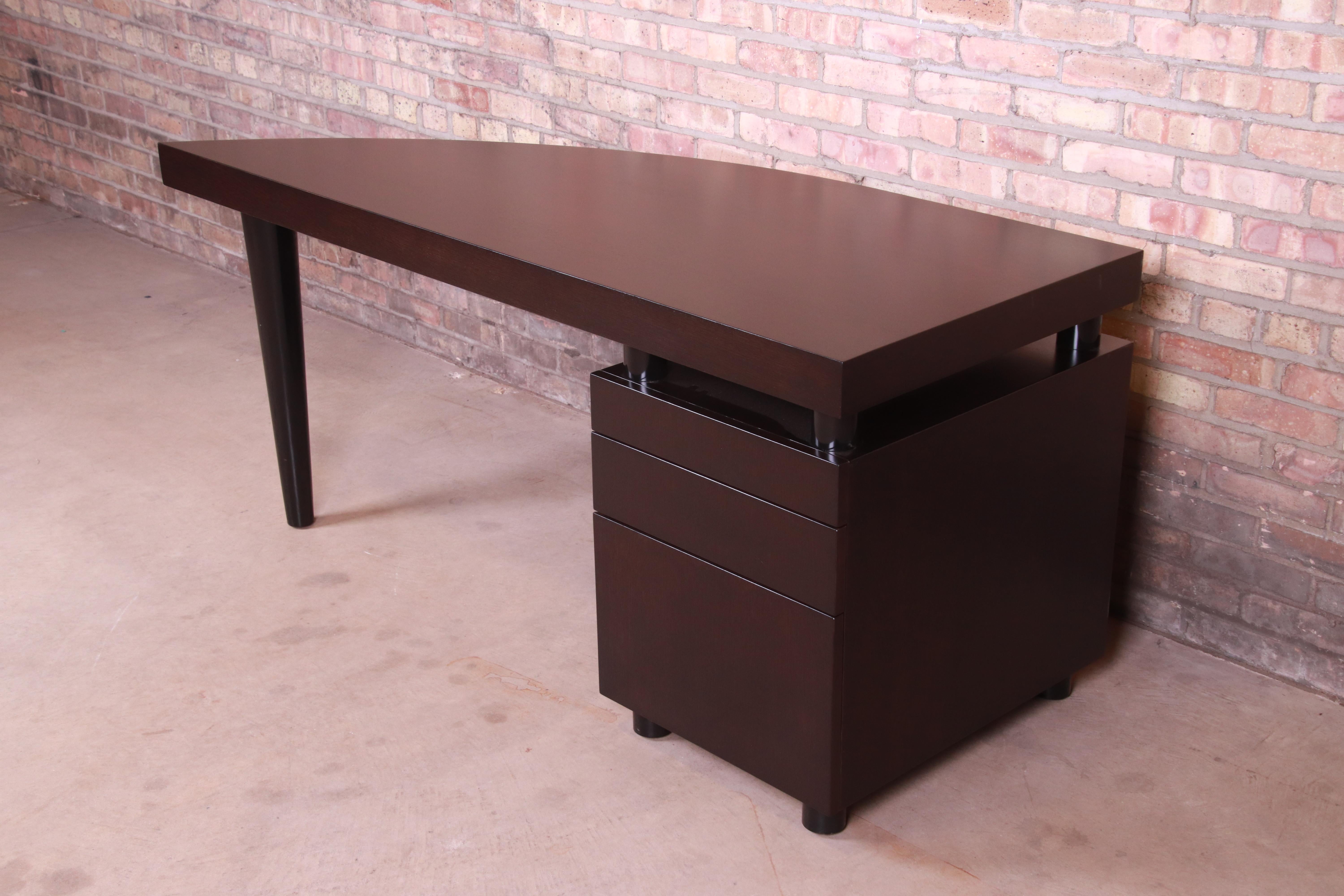 An exceptional Postmodern or Art Deco style executive writing desk

By Leon Rosen for Pace Collection

1980s

Mahogany, with unique sail-shaped top and black lacquered cylindrical legs.

Measures: 65.13