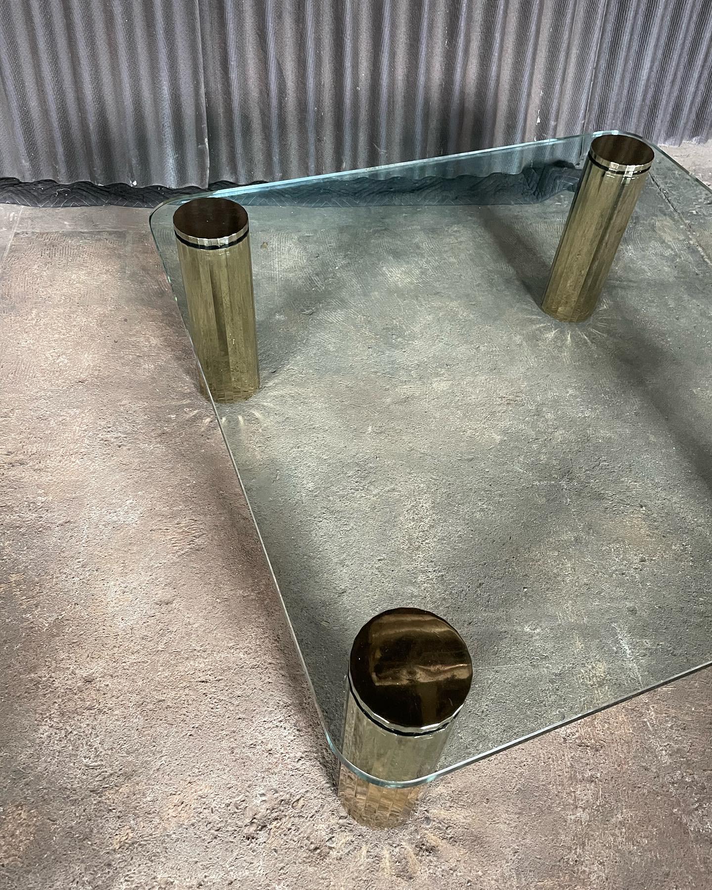 Incroyable et substantielle table de cocktail en verre et plaque de laiton dans le style de Leon Rosen pour Collectional.
Cette table est en très bon état, sans brisures ni éclats sur le verre et sans perte de placage de laiton sur les 4 pieds