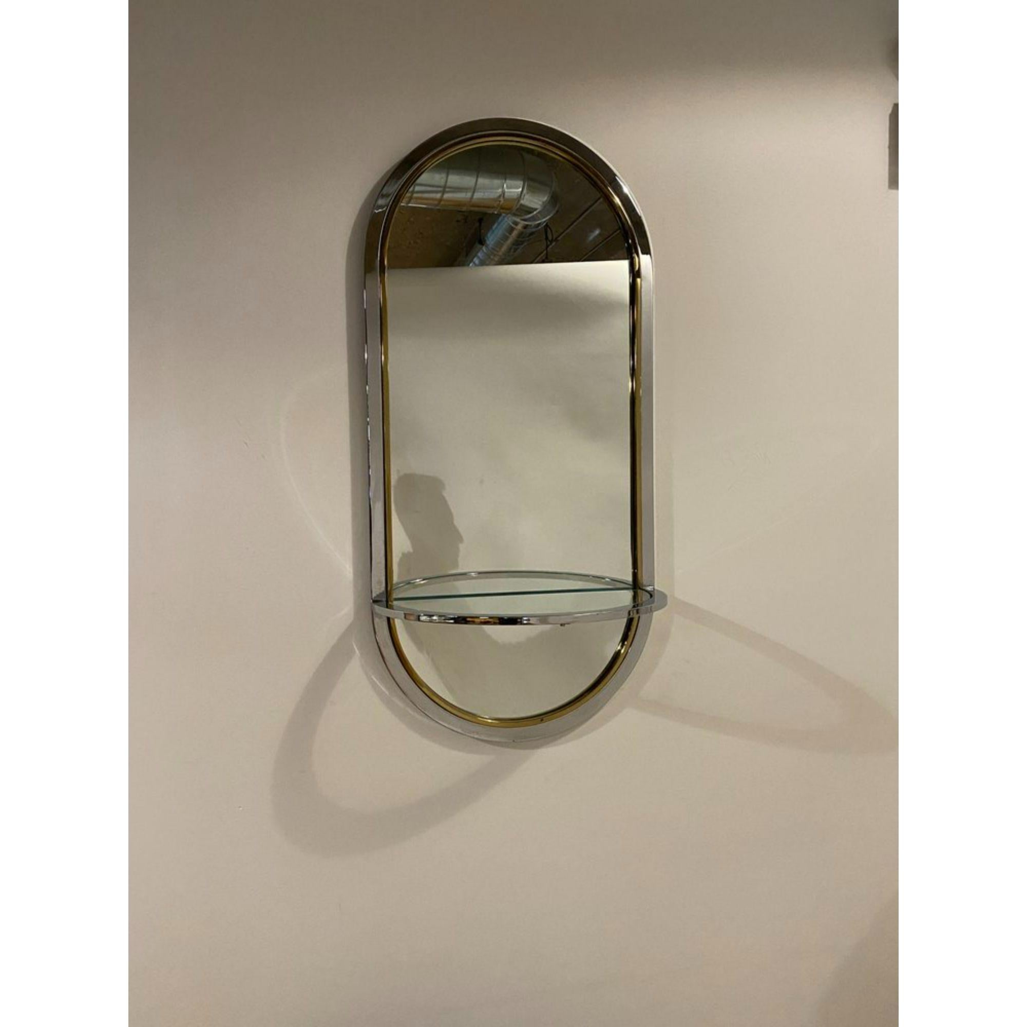 Postmodern chrome and brass racetrack wall mirror with a glass console shelf by Leon Rosen for Pace, 1970's.

Additional Information:
Materials: Brass Chrome Mirror
Color: Silver, gold
Style: Mid-Century Modern, Modern, Postmodern
Brand: Pace
