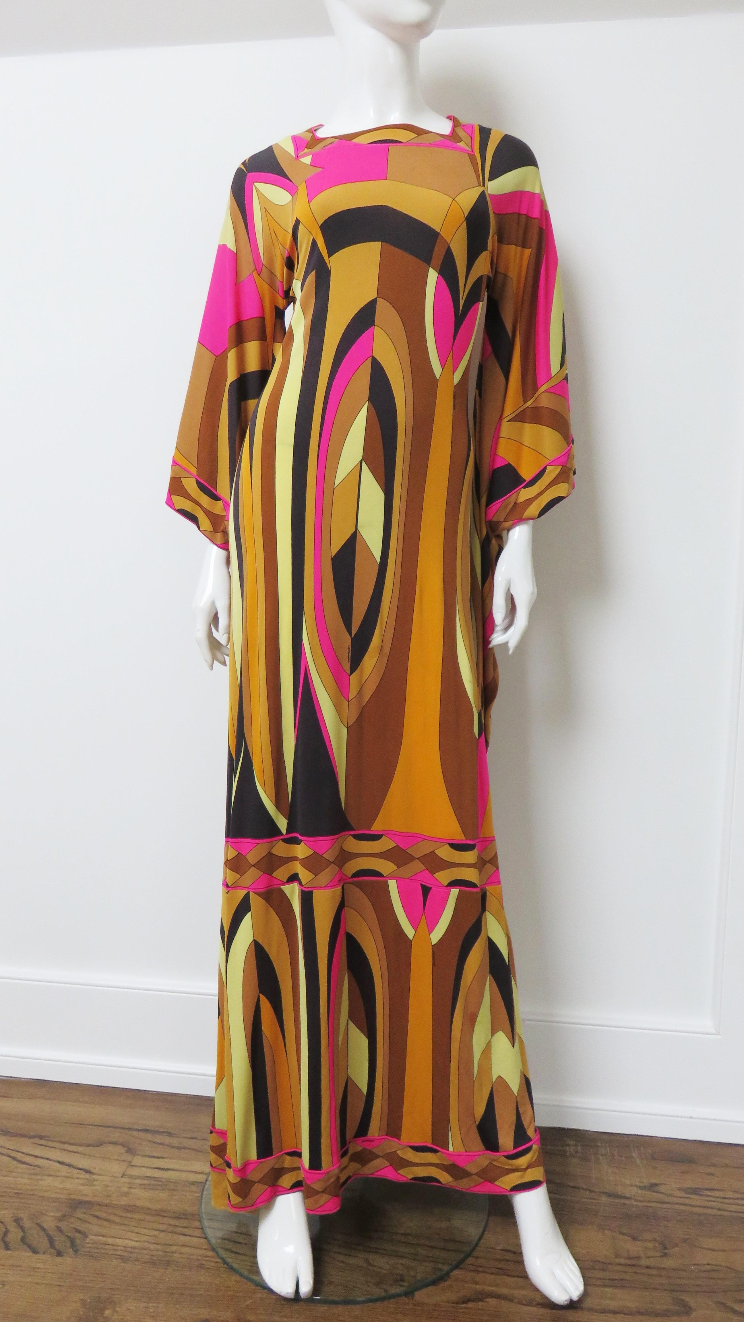 A fabulous angel sleeve long dress from Leonard in a bold pattern of bright pink, tan, black an yellow fine silk jersey.  It has a square neckline and long draping sleeves through to below the knees. It is semi fitted skimming the body.
Fits Extra