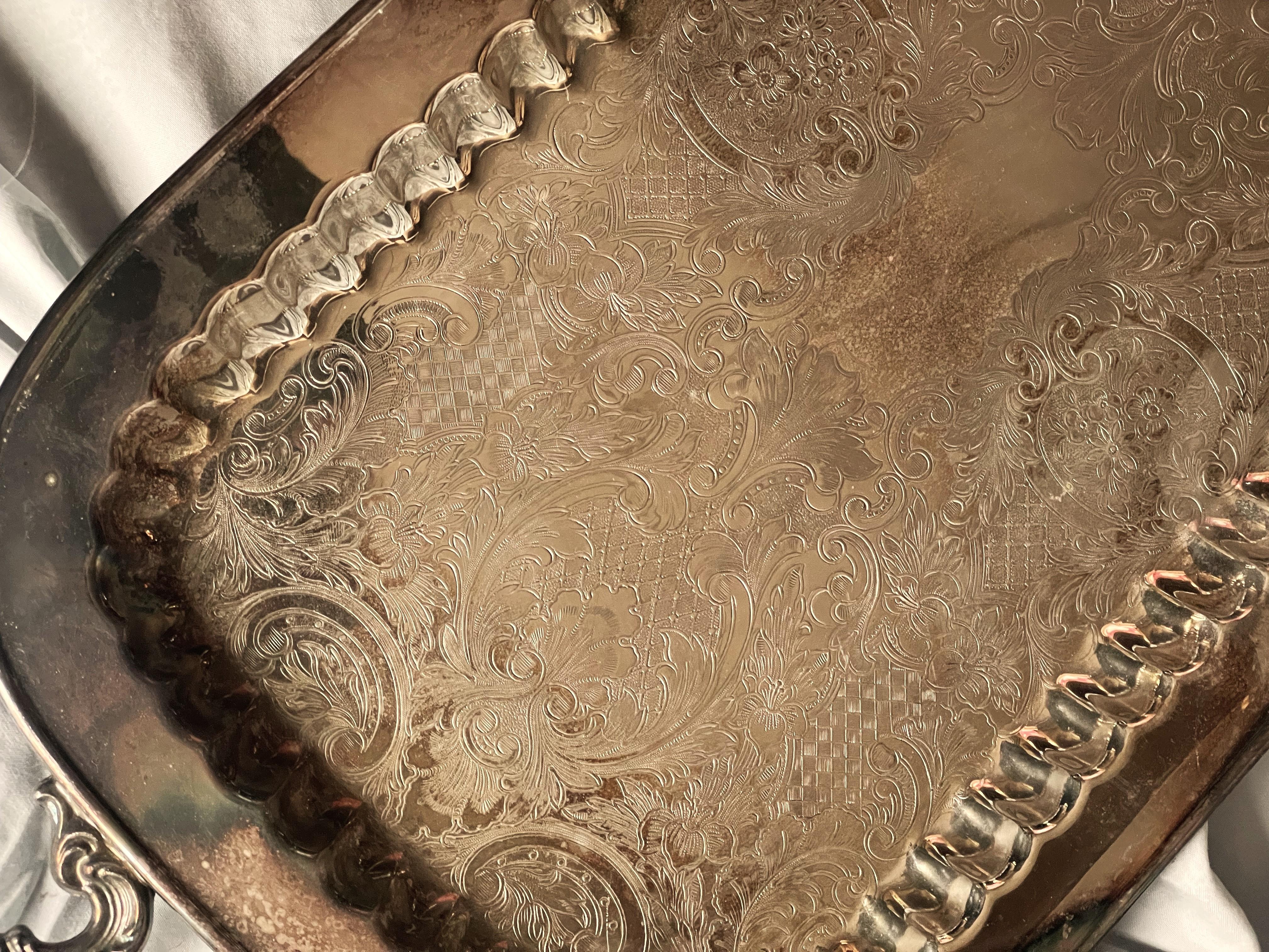 Here is a nice, large elongated silverplate tray by Leonard with two beautifully molded handles and a ribbed edge around the flat nicely etched center, the outside edge of the tray is rolled. 

The piece measures 24 1/2 inches handle to handle and