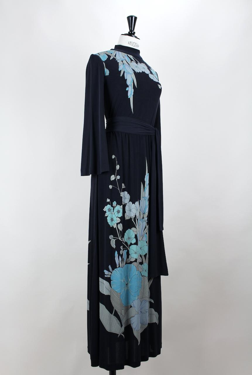 This stunning 1970s Leonard Fashion Paris maxi dress is a beautiful and quite unusual Leonard design with its wonderful subtly coloured floral print on a black backdrop.

It is made from a fine silk jersey and has a fitted cut through bodice with