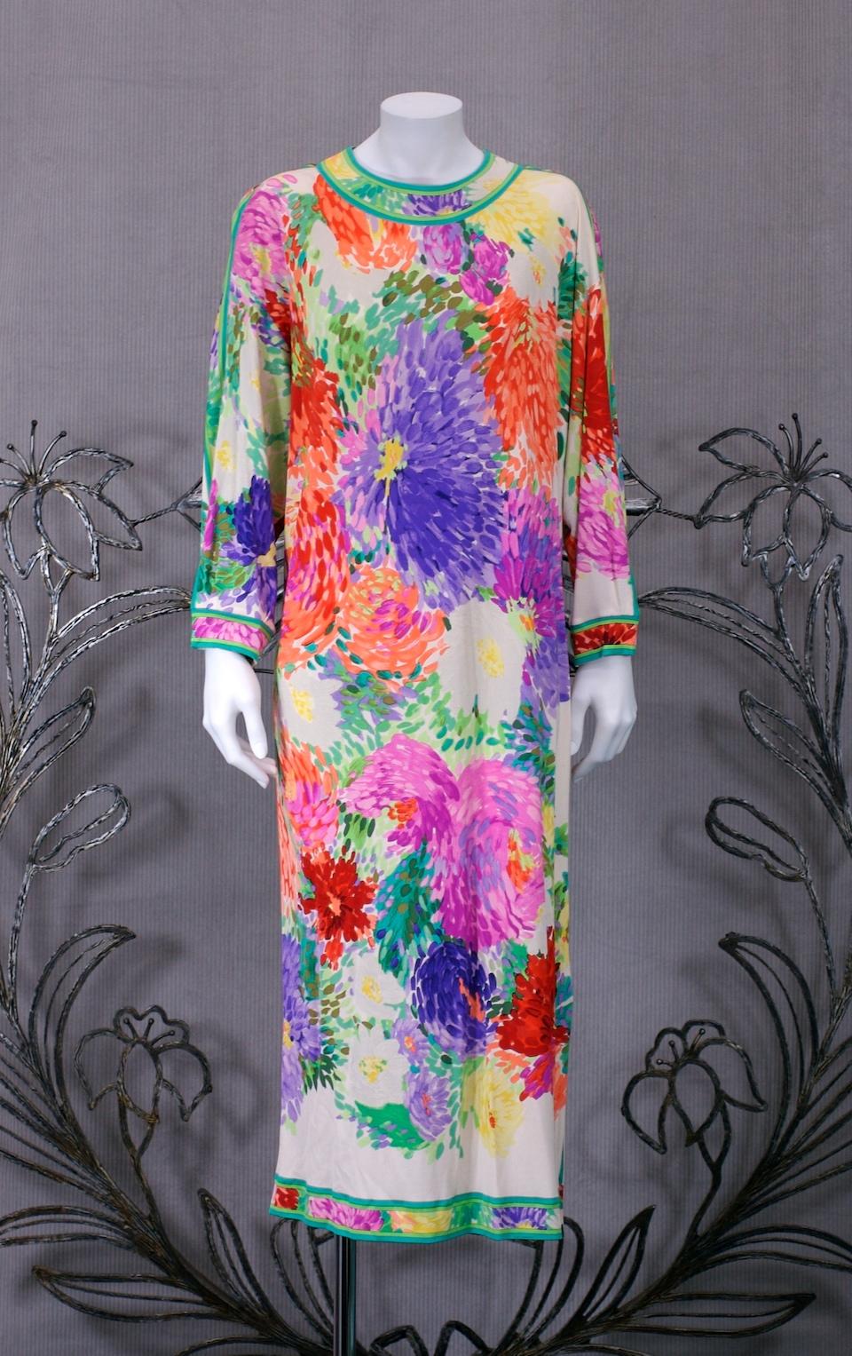 Leonard Paris Easy Silk Jersey Dress with vibrant floral print.  A simple tapered T shirt shape with deep dolman sleeves which taper above the wrist.  Signature detailed trim is used along neckline, shoulders and hem. Self fabric belt with gilt tips
