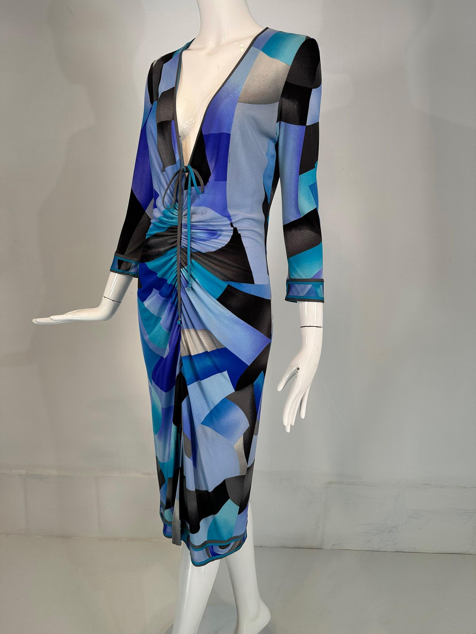 Leonard Paris silk geometric print jersey dress hidden zipper front closure with ties. Bright shades of blue, white, black print silk jersey pull on dress with 3/4 length sleeves & a plunge V neckline. The dress has a zipper front closure that can