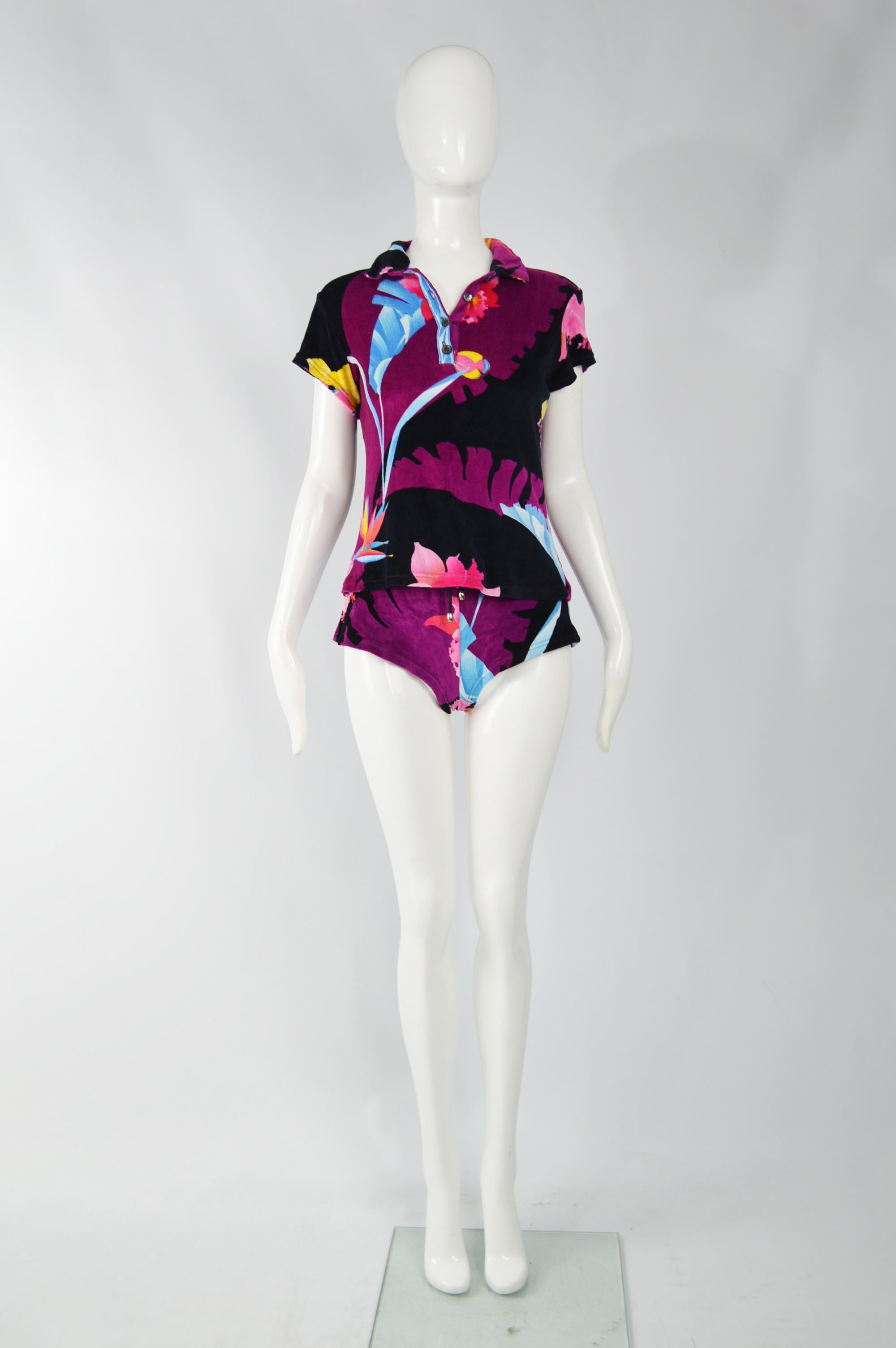 A super cute vintage womens two piece shorts and t shirt suit 2 piece ensemble by Leonard Paris. In a purple, black and white tropical printed velour / stretch velvet fabric. The shorts have a sexy, hot pants silhouette and the top has a polo shirt