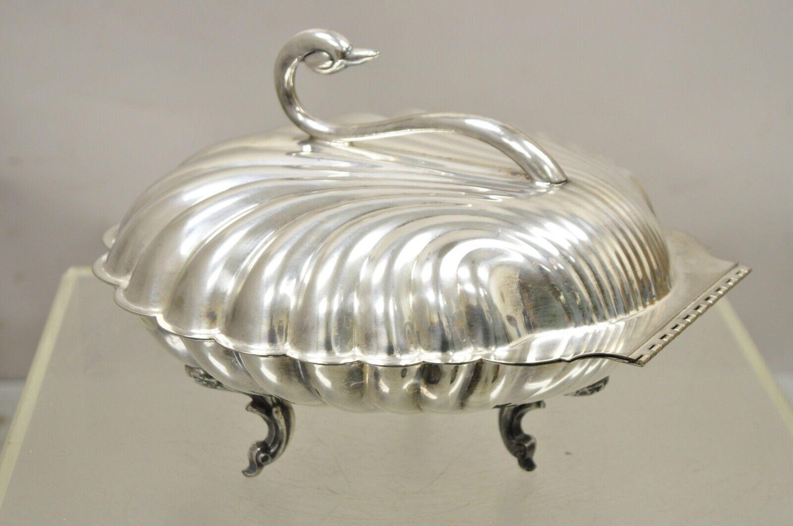 Réchaud à charnière en métal argenté Leonard en forme de coquille de palourde avec cygne. L'objet présente une poignée en forme de cygne orné, reposant sur trois pieds, une grande forme à charnière, un poinçon d'origine. Circa  Milieu du 20e siècle.