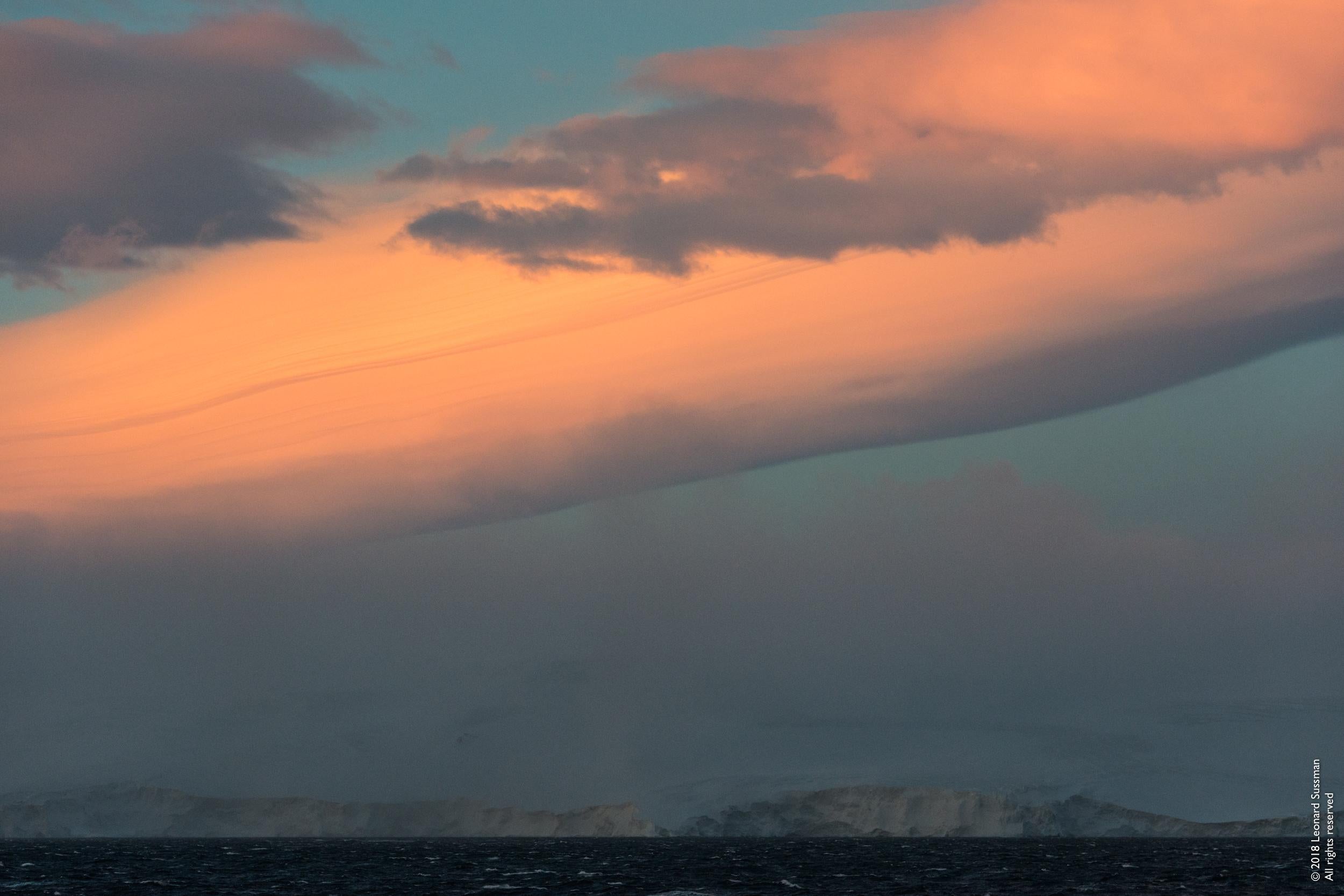 From the artist:

"ANTARCTIC SOUND, LAT. 63°35’S, LONG. 55°47’W, High Winds

I have never seen a more amazing sunrise than this one as we entered Antarctica. We were fortunate not to find the area blocked by sea-ice. We were told by the captain that