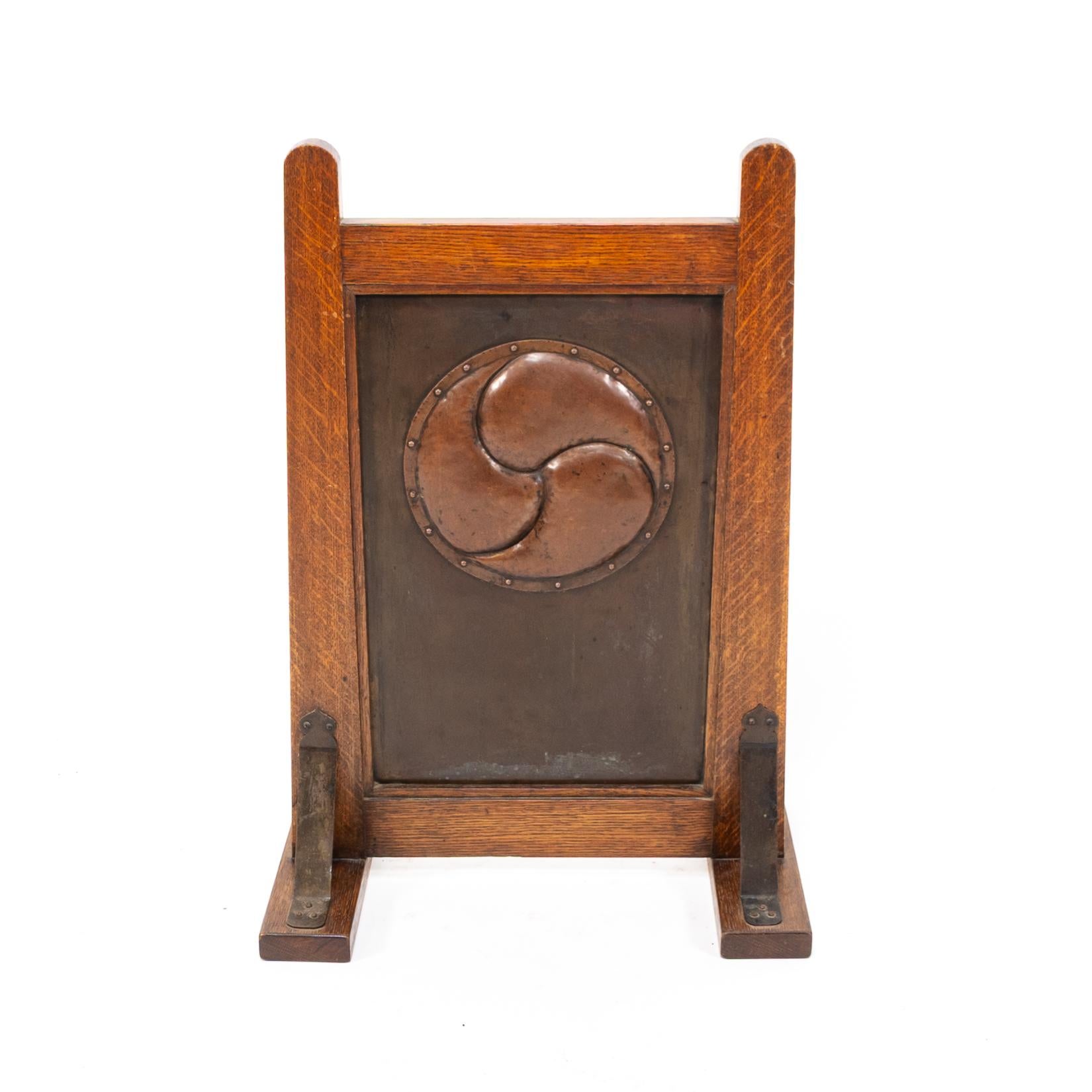 Liberty & Co., attribuito, a Leonard Wyburd
Un raro parafuoco in legno di quercia decorato con un dispositivo circolare in rame martellato e rivettato a mano al centro.
Si regge su piedi a slitta con staffe in rame alla base.