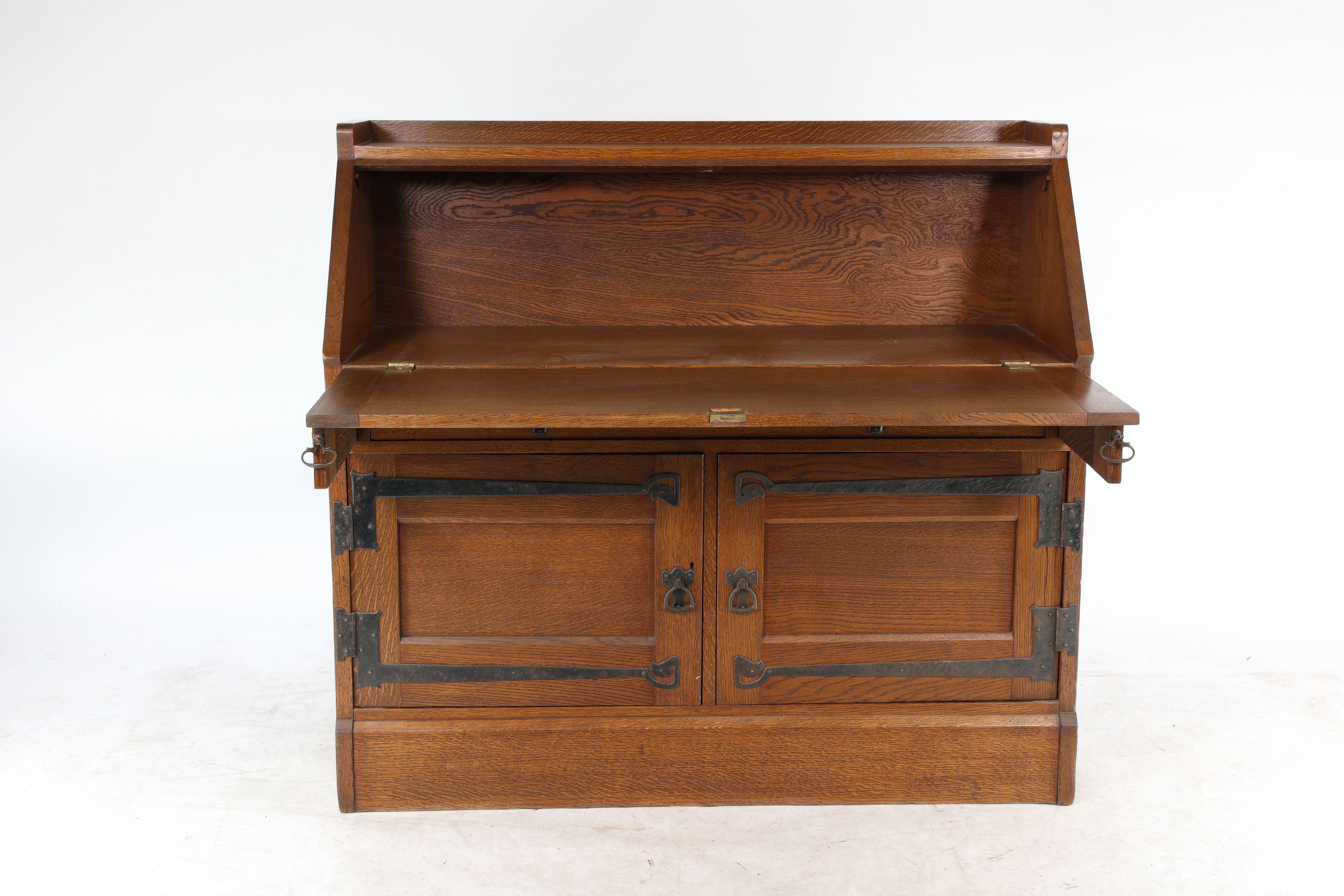English Leonard Wyburd for Liberty & Co. An Arts & Crafts oak bureau with iron hinges For Sale