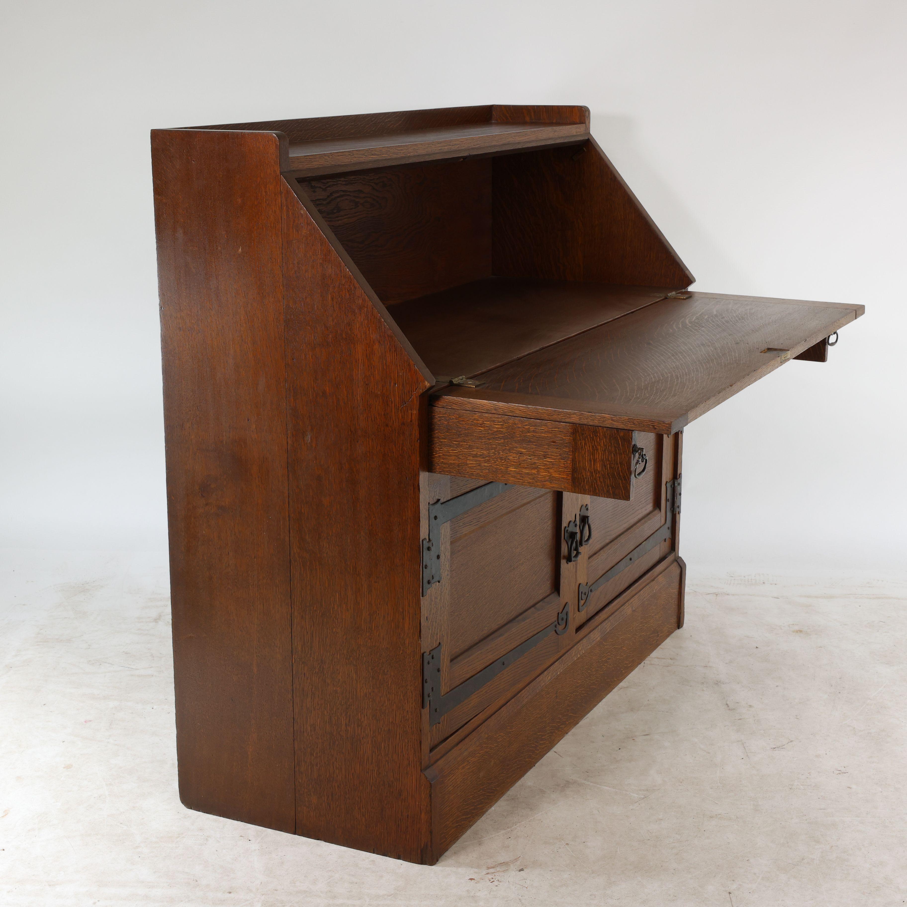 Early 20th Century Leonard Wyburd for Liberty & Co. An Arts & Crafts oak bureau with iron hinges For Sale