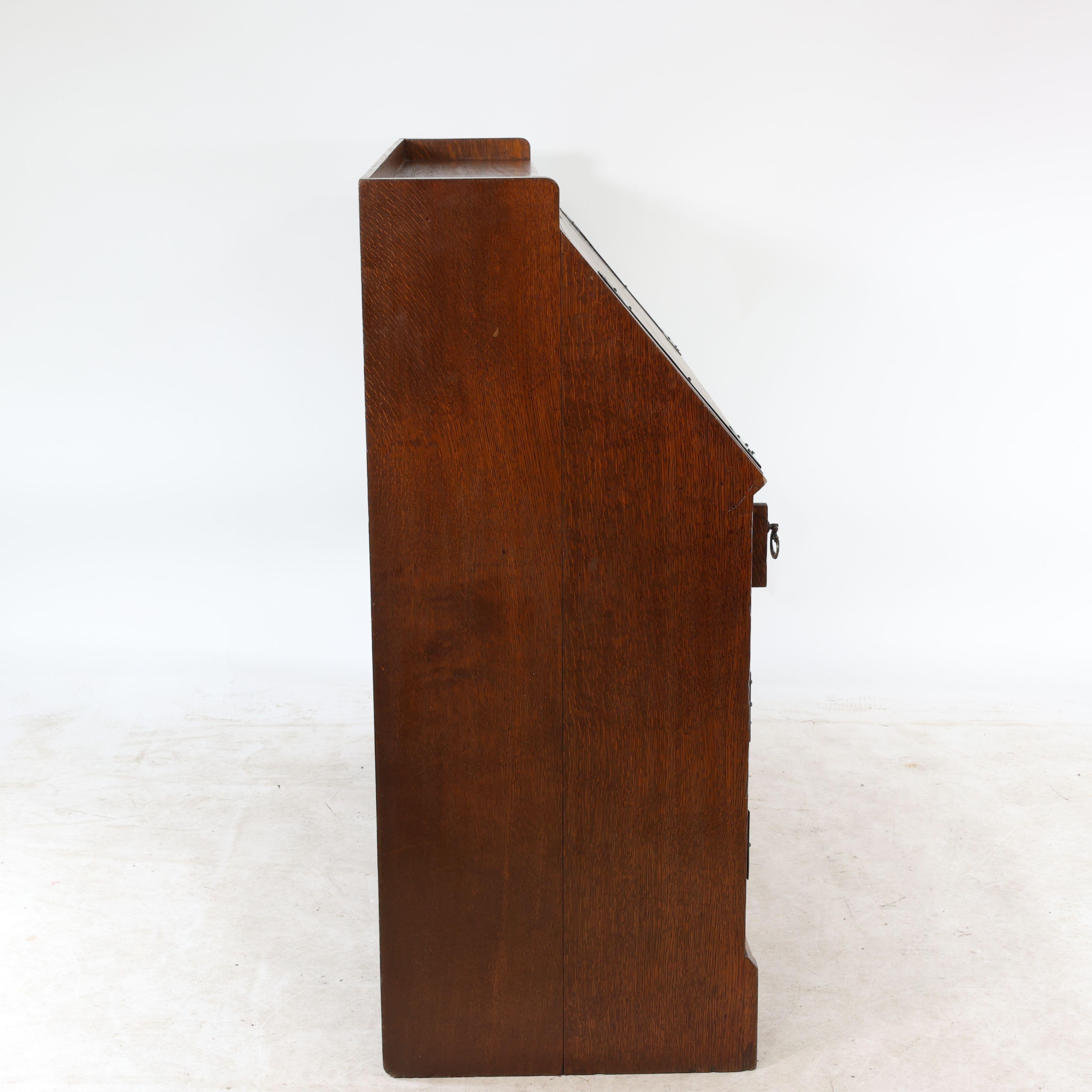 Leonard Wyburd for Liberty & Co. An Arts & Crafts oak bureau with iron hinges For Sale 1