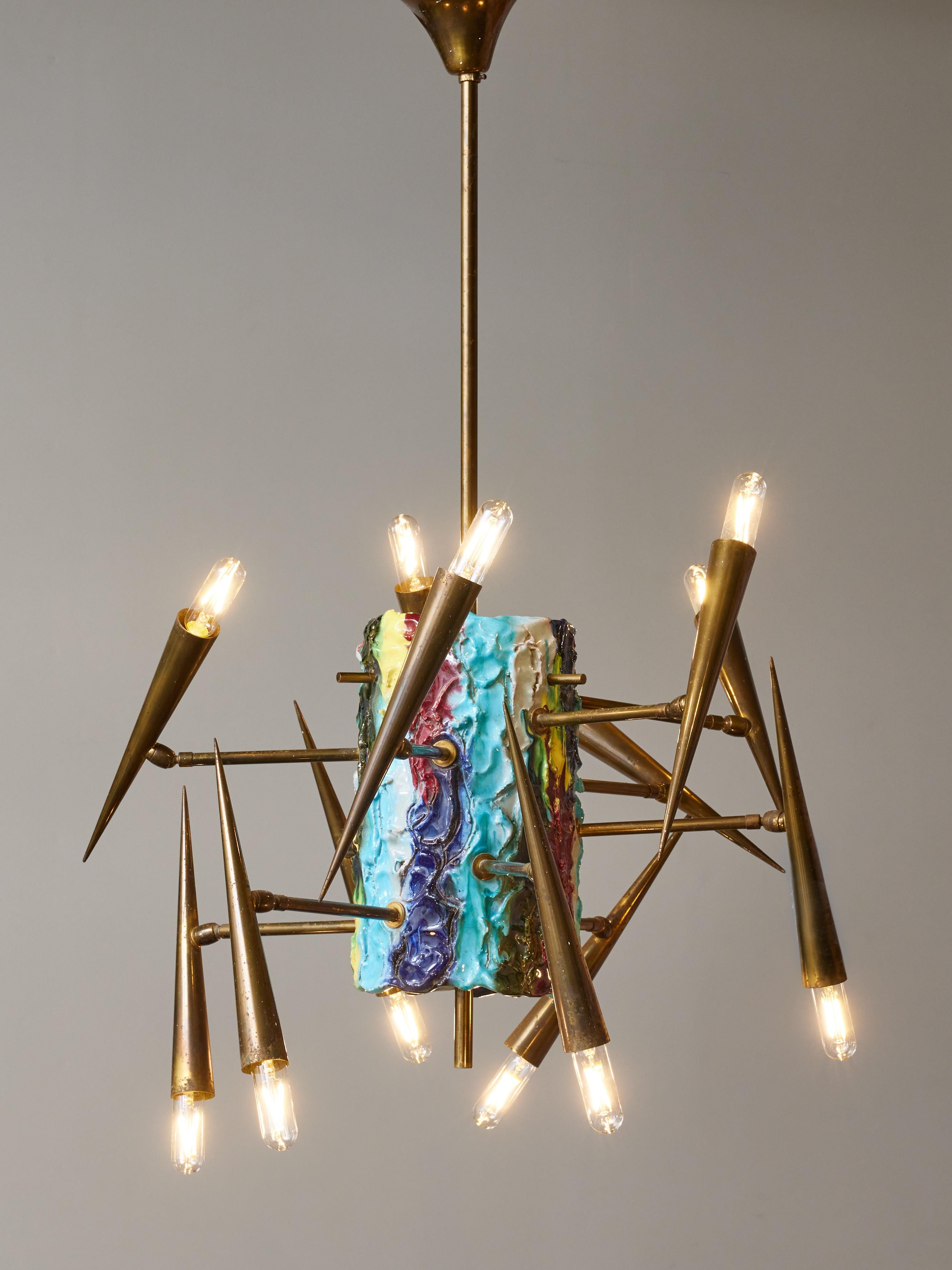 Unusual piece made by the Italian artist Leoncillo Leonardi for Lumi Milano, this chandelier is made of a ceramic painted cylinder and twelve pointy arms of light typical of the mid century style.

Leoncillo Leonardi (1915 - 1968)
Italian