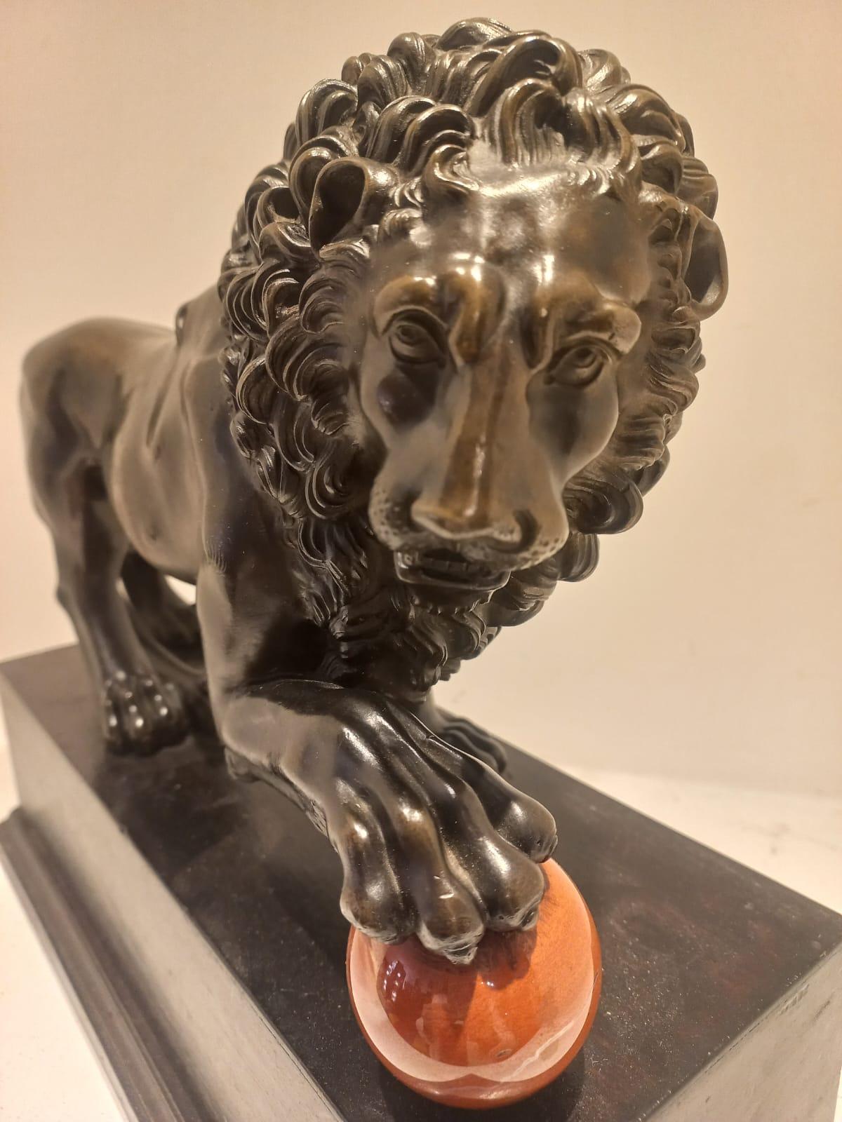 Burnished Lion with paw on cannonball For Sale