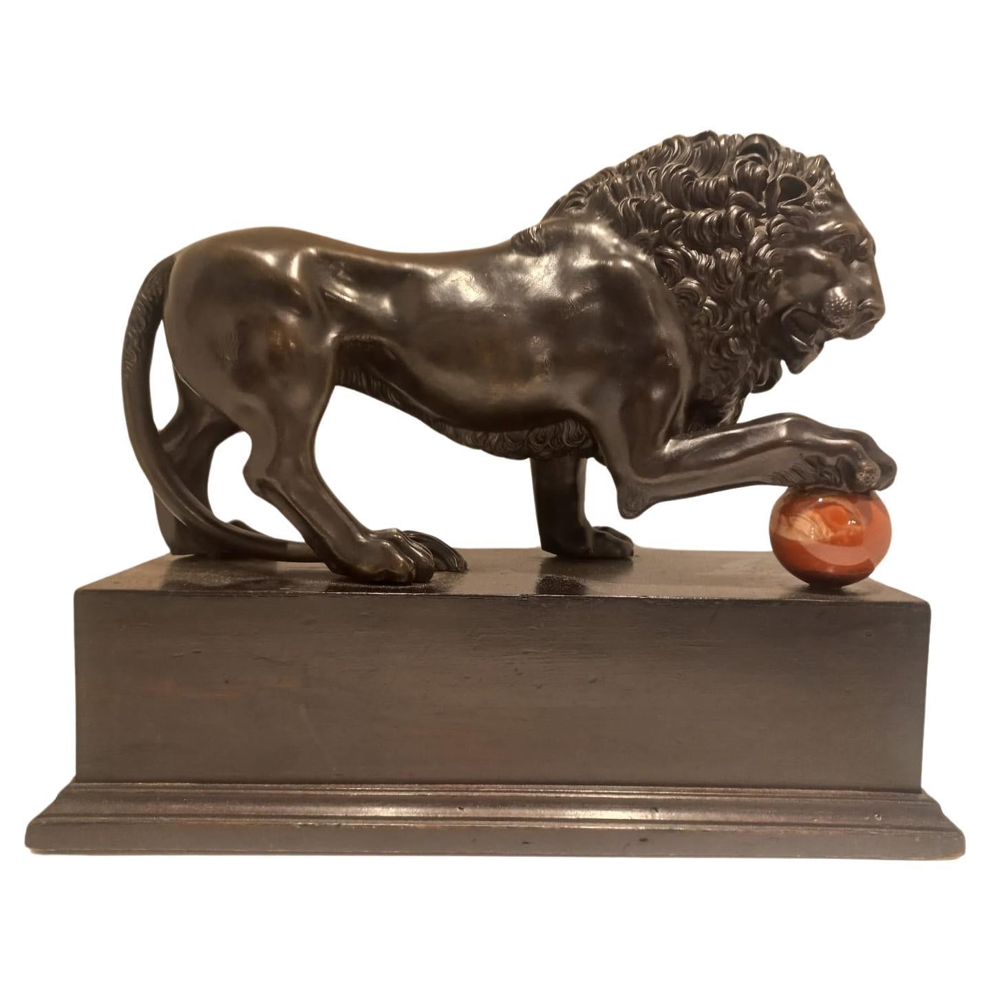 Lion with paw on cannonball For Sale