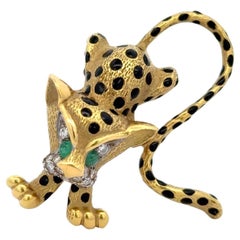 Broche léopard en or jaune 18 carats et émail. La broche est ornée de diamants et d'em