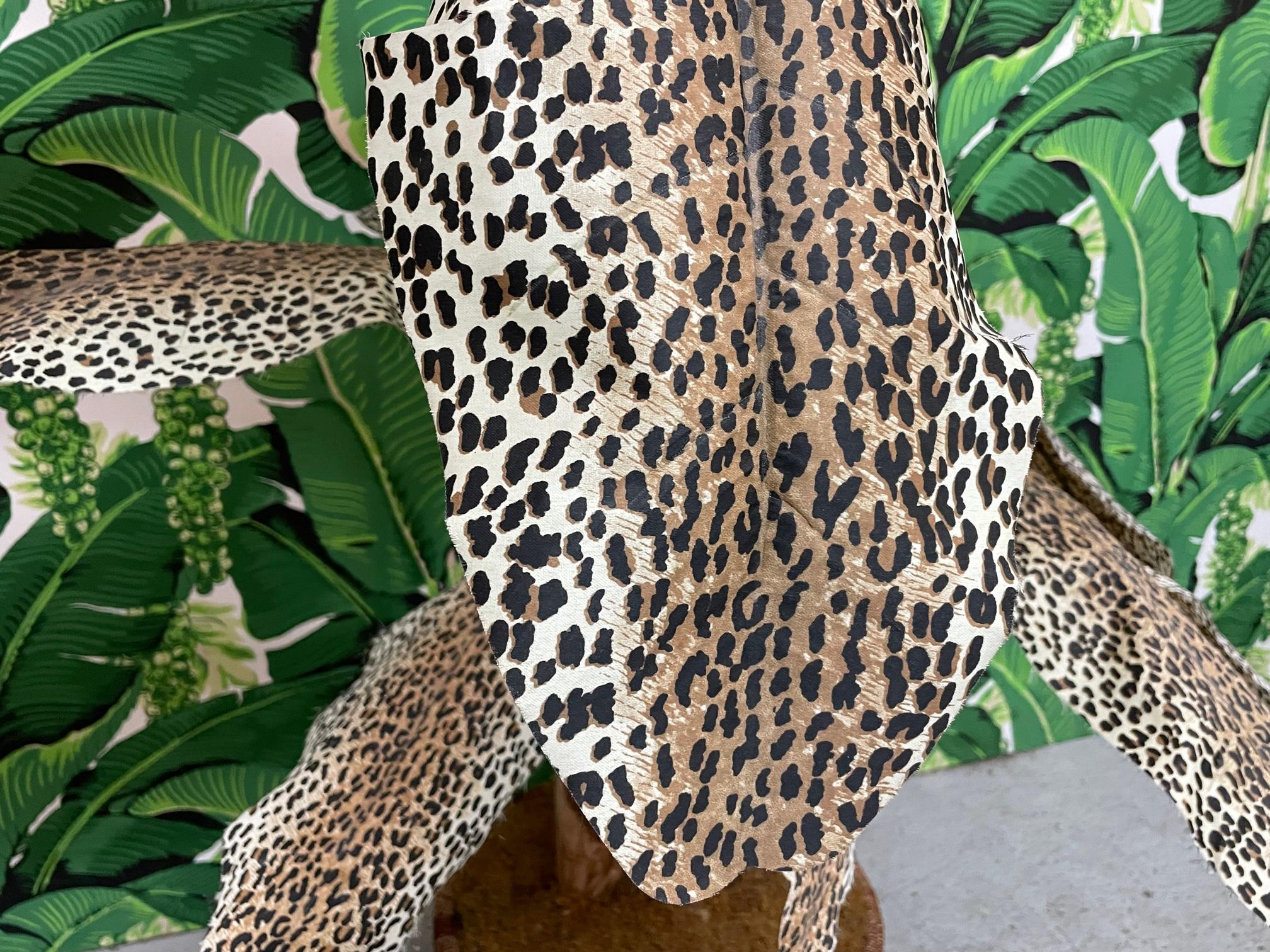 Large artificial palm tree features leaves made from leopard print canvas fabric. Two stalks, large and small, and a woven rattan planter. Very good condition with only minor imperfections consistent with age.

 
