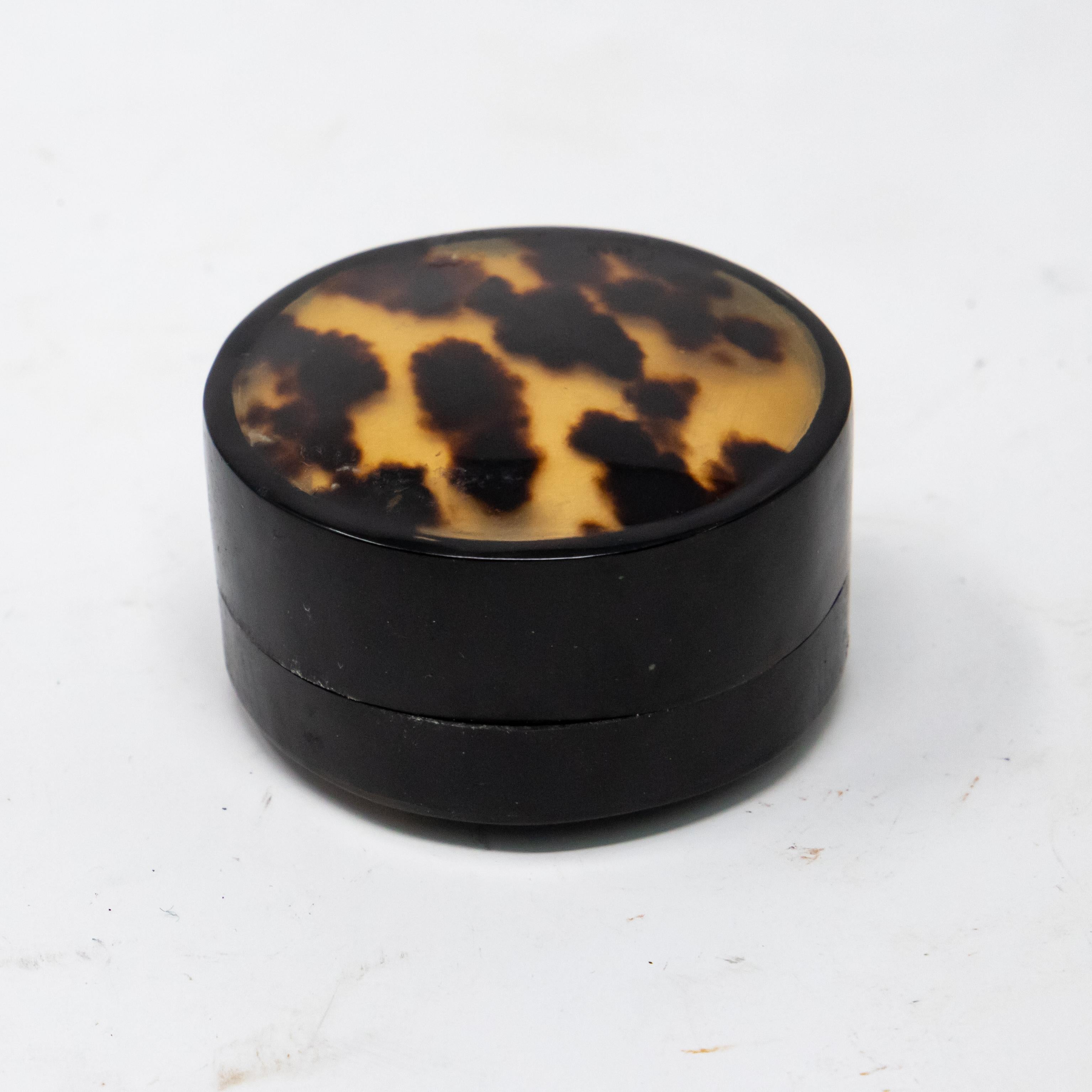 Lacquered sides with leopard print painting on an amber surface on the top. Small pill/trinket box.