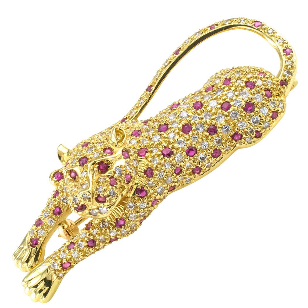 1980s Leopard brooch set with rubies and diamonds set in gold. Sleek as only a cat can be, this leopard, one of the great cats in nature, is spotted with rubies on a body that is totally defined by sparkling diamonds totaling approximately 2.33