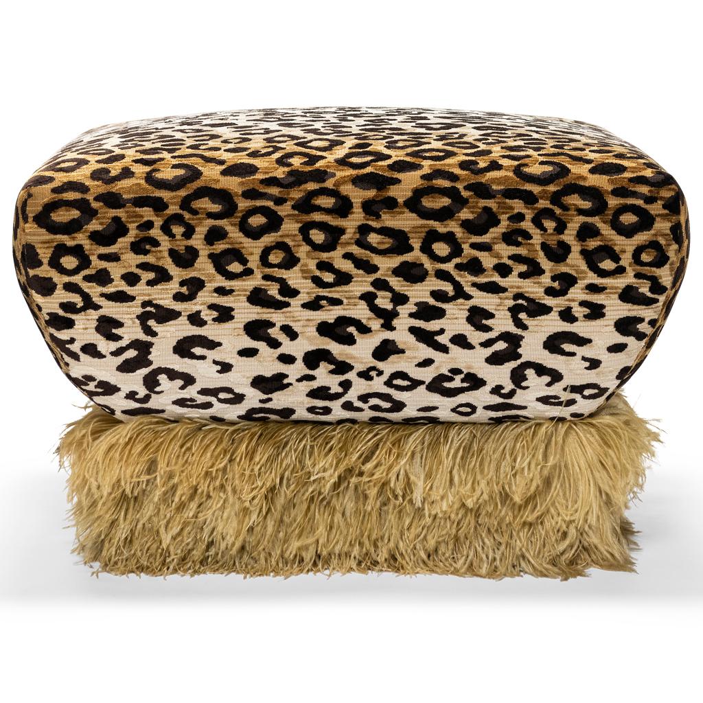 This gorgeous Leopard velvet ottoman is a harmonious play on materials that results in sophisticated statement piece. 
The ottoman is trimmed with a genuine champagne colored ostrich feather trim which creates a wispy floating effect. 
This ottoman