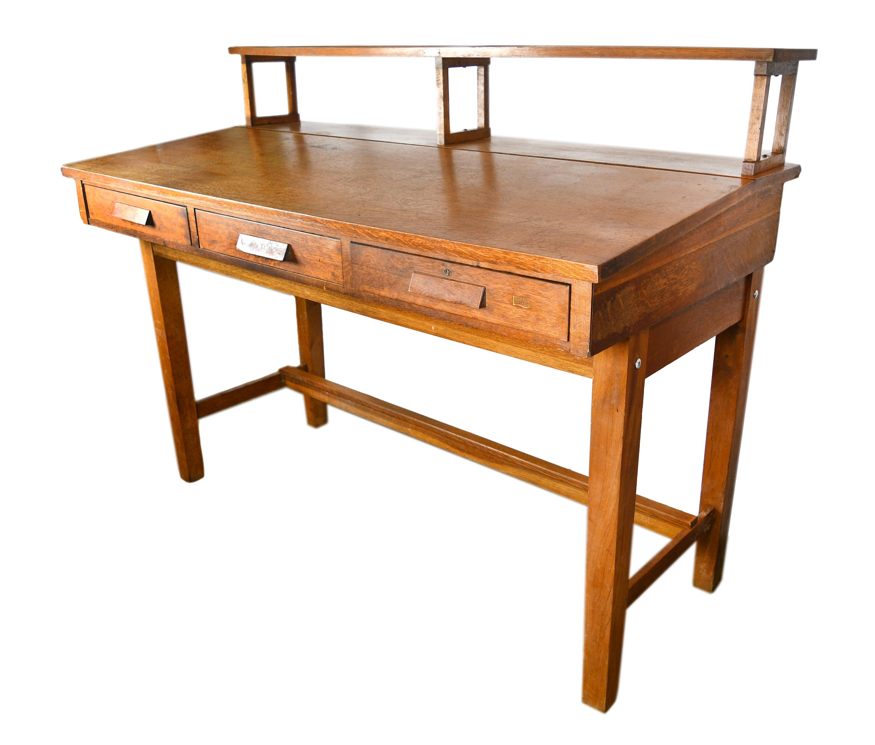 This gorgeous Leopold Desk Company standing desk is made of lovely quartersawn oak and features three large drawers. The Leopold Desk Company was an office furniture manufacturing firm in Burlington, Iowa. In it’s prime, the company produced 30,000