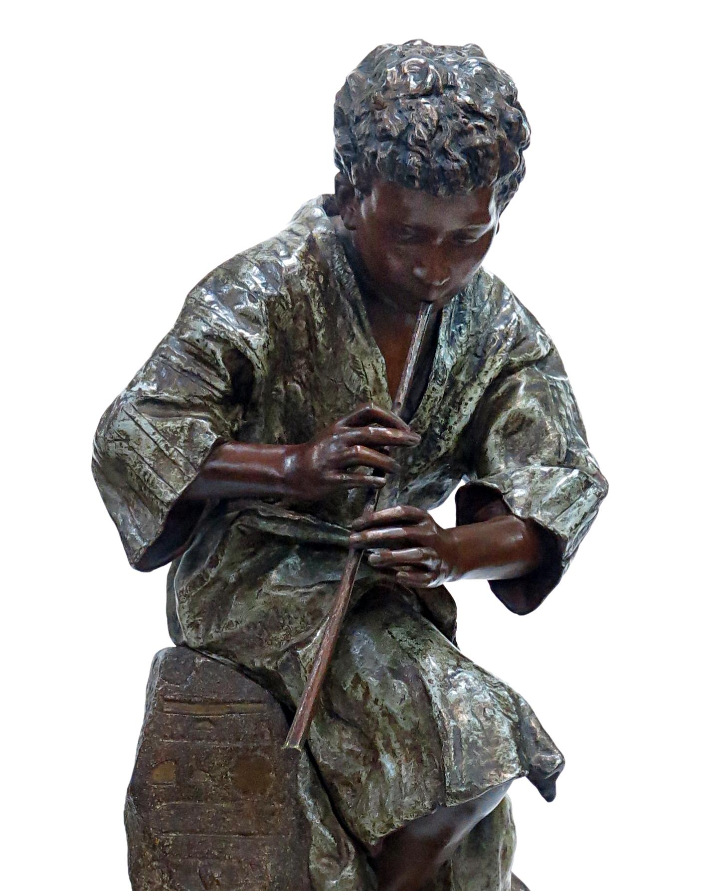 Massive orientalist sculpture made out of polychrom spelter, representing a young snake charmer near a fig tree, sat on a rock, playing the flute with a snake at his feet. Rotating base decorated with oriental motives in the style of bronze. Signed