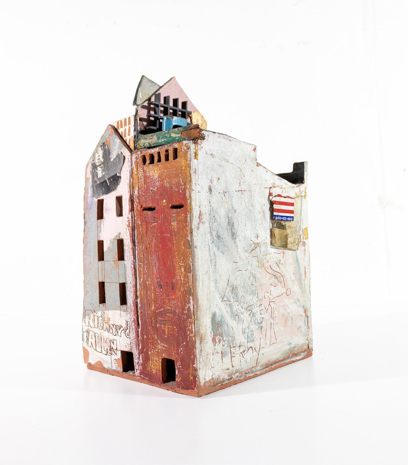 Rather than being literal reproductions of buildings, Leroy Johnson’s iconic, signature house sculptures are alive with texture and symbolism, celebrating the resilience of communities while offering a poignant perspective from an African American