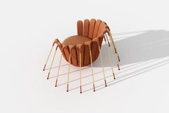 Fauteuil Les Araignée de Marc Ange avec pieds dorés et tapisserie rouge safran