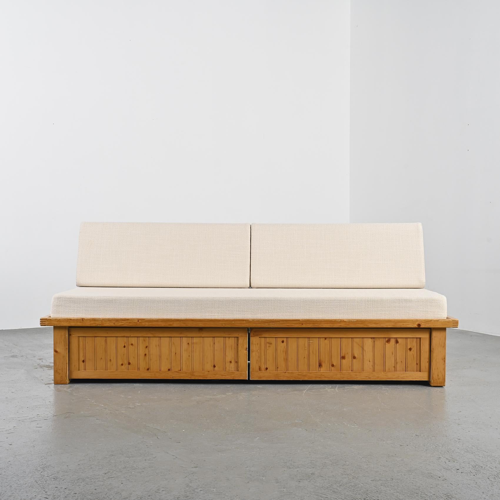 Imagined by Charlotte Perriand, this sofa bed was once part of the furnishings in the apartments of the Residence Nova in Les Arcs.

The structure of this piece is crafted with pine slats and conceals two rolling drawers accessible through a flap.