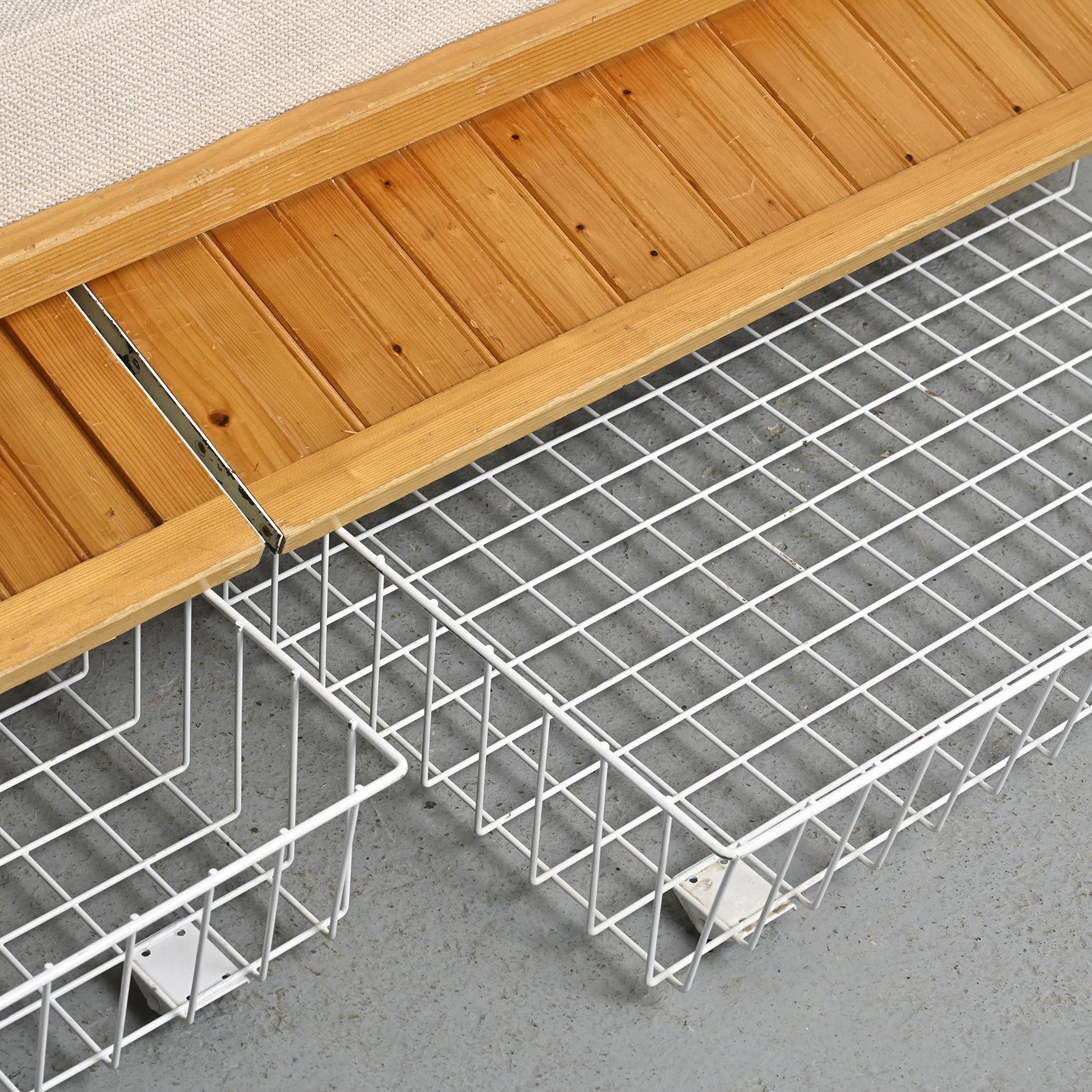 Imagined by Charlotte Perriand, this sofa bed was once part of the furnishings in the apartments of the Residence Nova in Les Arcs.

The structure of this piece is crafted with pine slats and conceals two rolling drawers accessible through a flap.