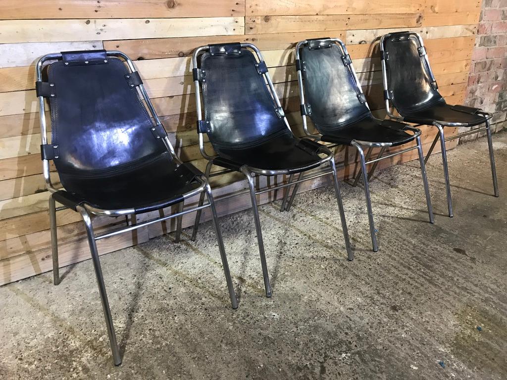 Ensemble inhabituel de 4 chaises en cuir teinté noir, conçues / choisies par Charlotte Perriand pour et utilisées dans la station de ski Les Arcs, vers 1960. 

Ces chaises ont été commandées par DalVera. Très beau cadre tubulaire chromé avec des