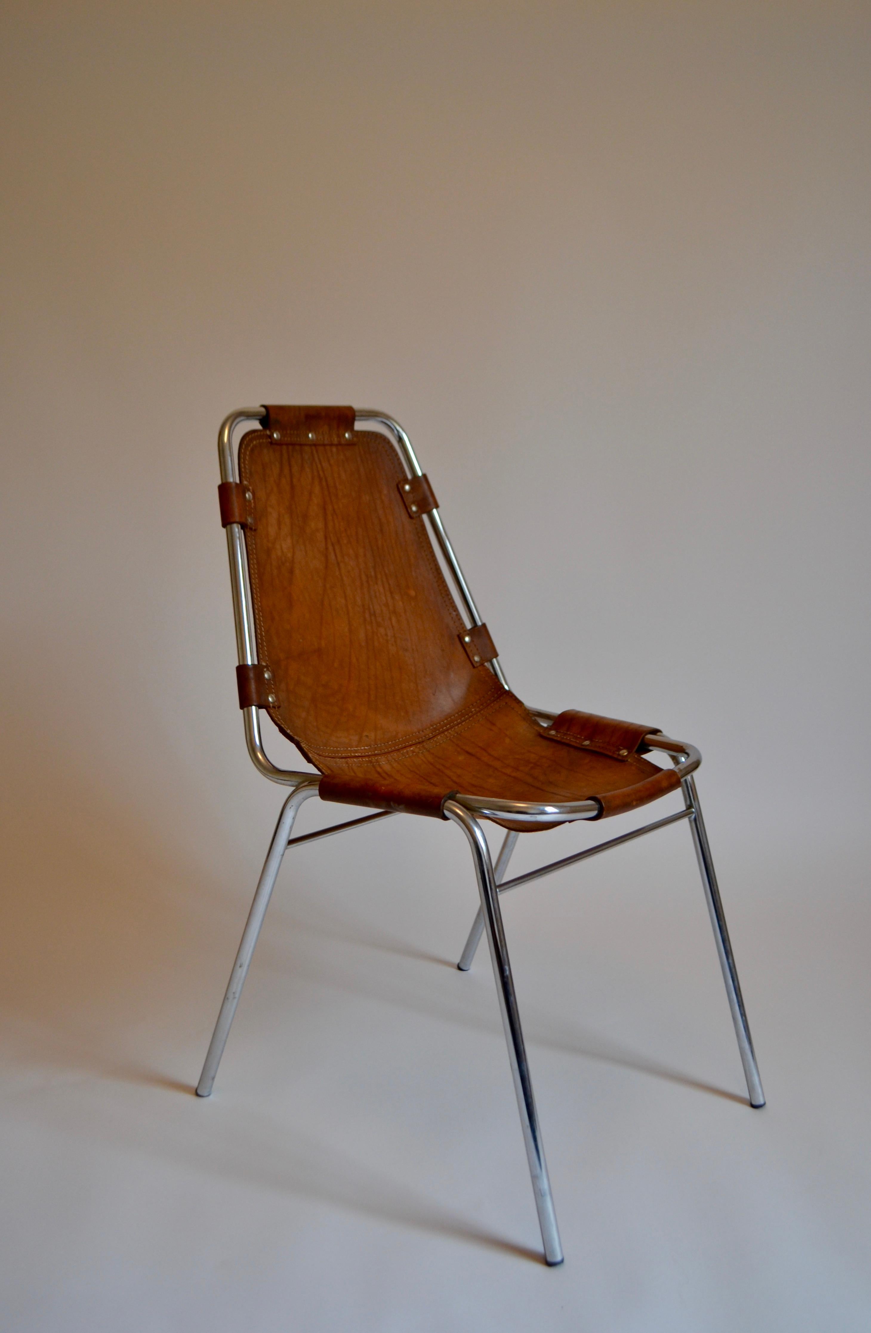 Les Arcs chair designed by Charlotte Perriand for the Les Arcs ski resort in Savoie, in the late 1960s. Cognac leather seat on a tubular chrome frame. Creasing and wear to the leather as pictured.