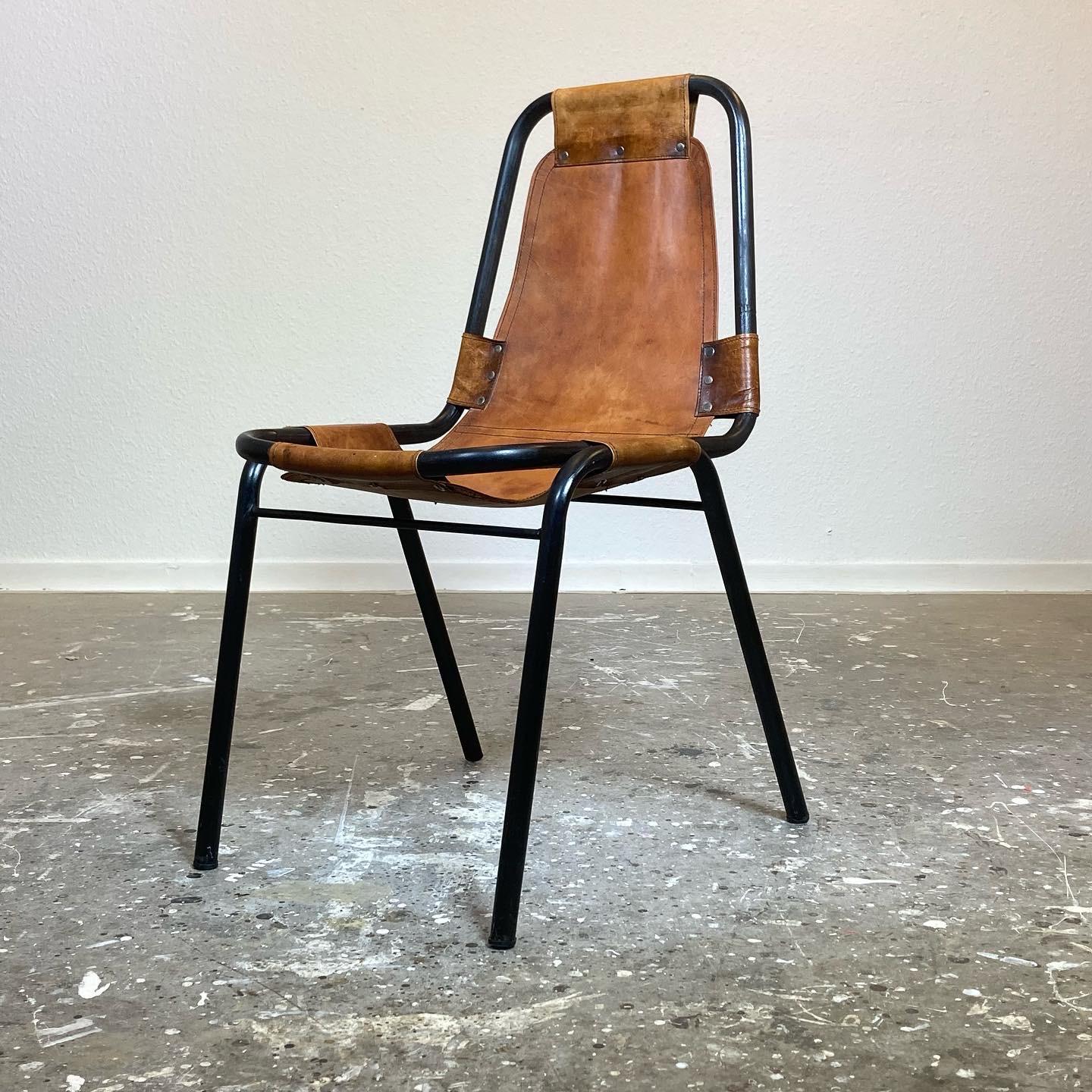 Original Les Arcs chair by Charlotte Perriand for the ski resort of the same name designed and project managed by Perriand. Beautiful patina on the leather riveted to the black tubular steel frame. In good vintage condition and from the first series