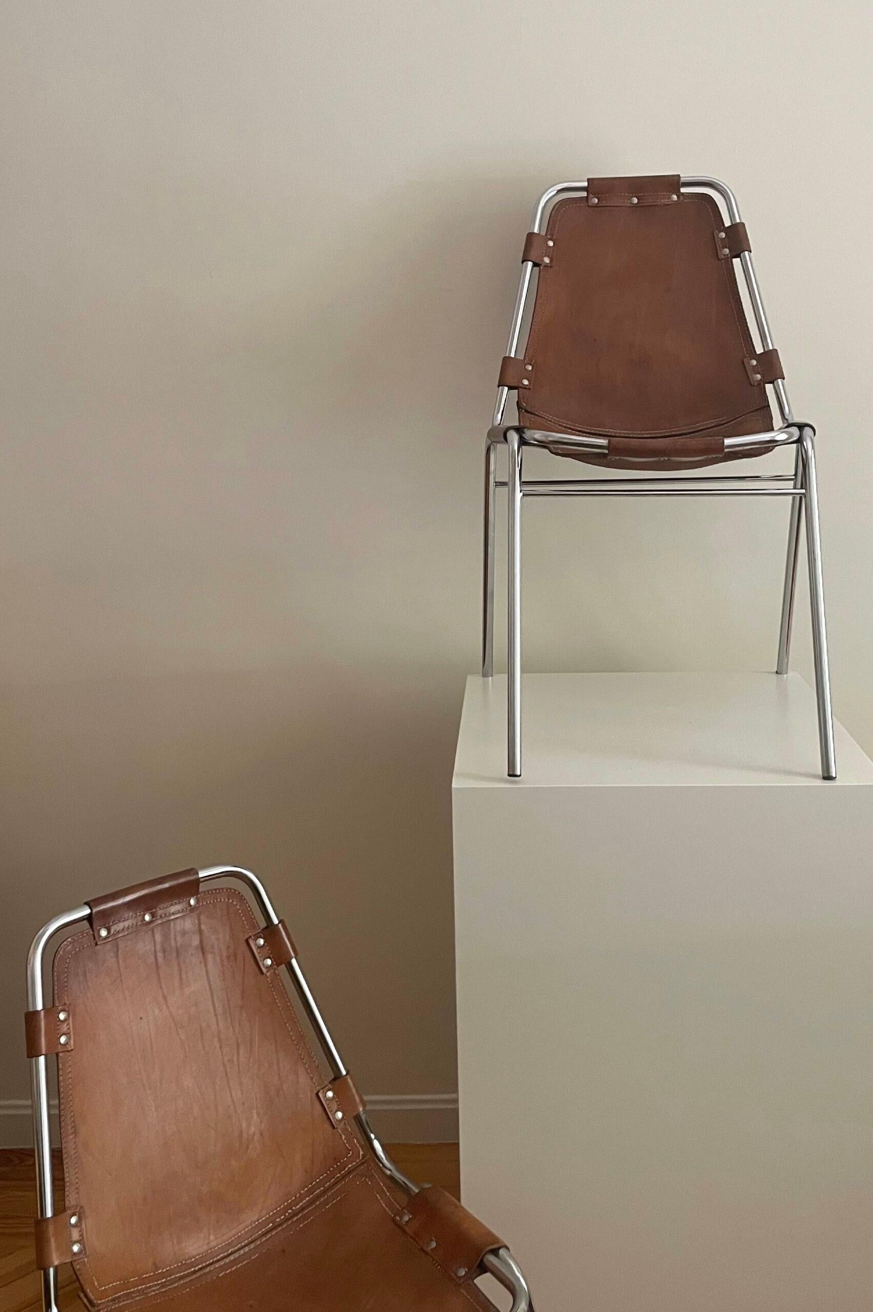 Le sedie Les Arcs sono state progettate da Charlotte Perriand per la località alpina di Les Arcs, nella valle della Tarentaise, negli anni '60. Set di 4 sedie. Pelle di sella originale. Leggera patina sul cromo e sulla pelle commisurata all'età e