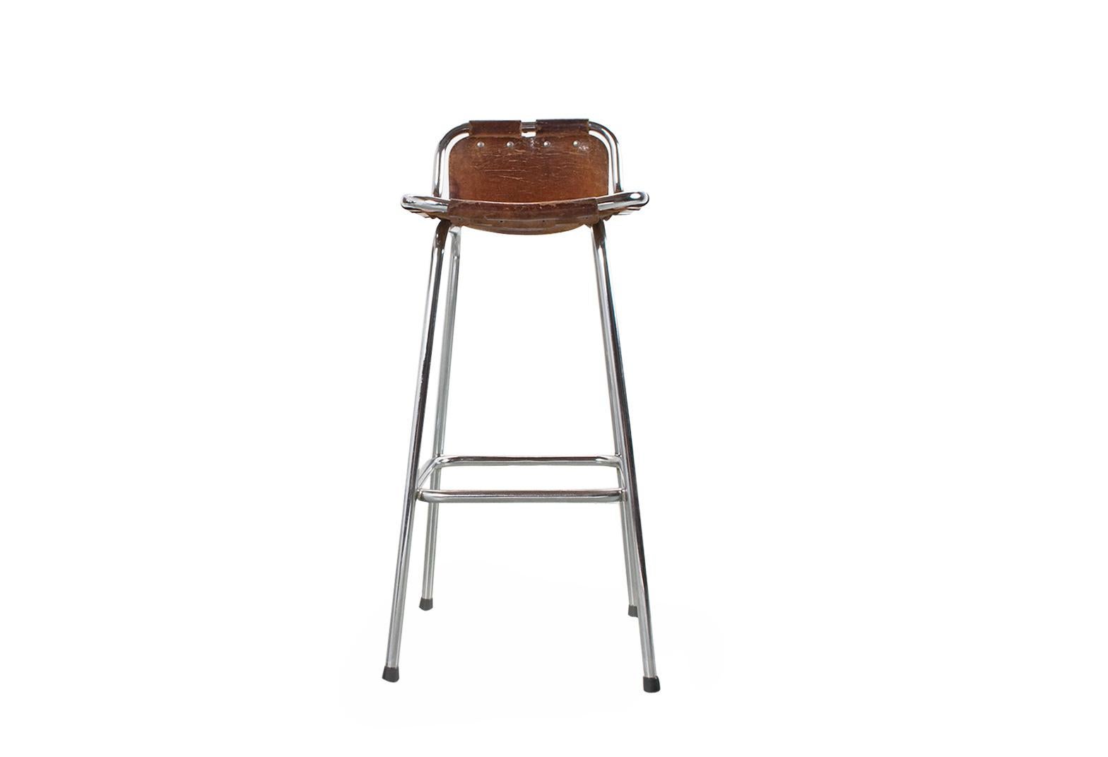 An original Mid-Century Modern French high bar stools with brown camel colored saddle leather sling seat, on a chromed tubular frame. Selected by Charlotte Perriand for the “Les Arcs” ski resort in France, 1960s. The chromed frame is in very good